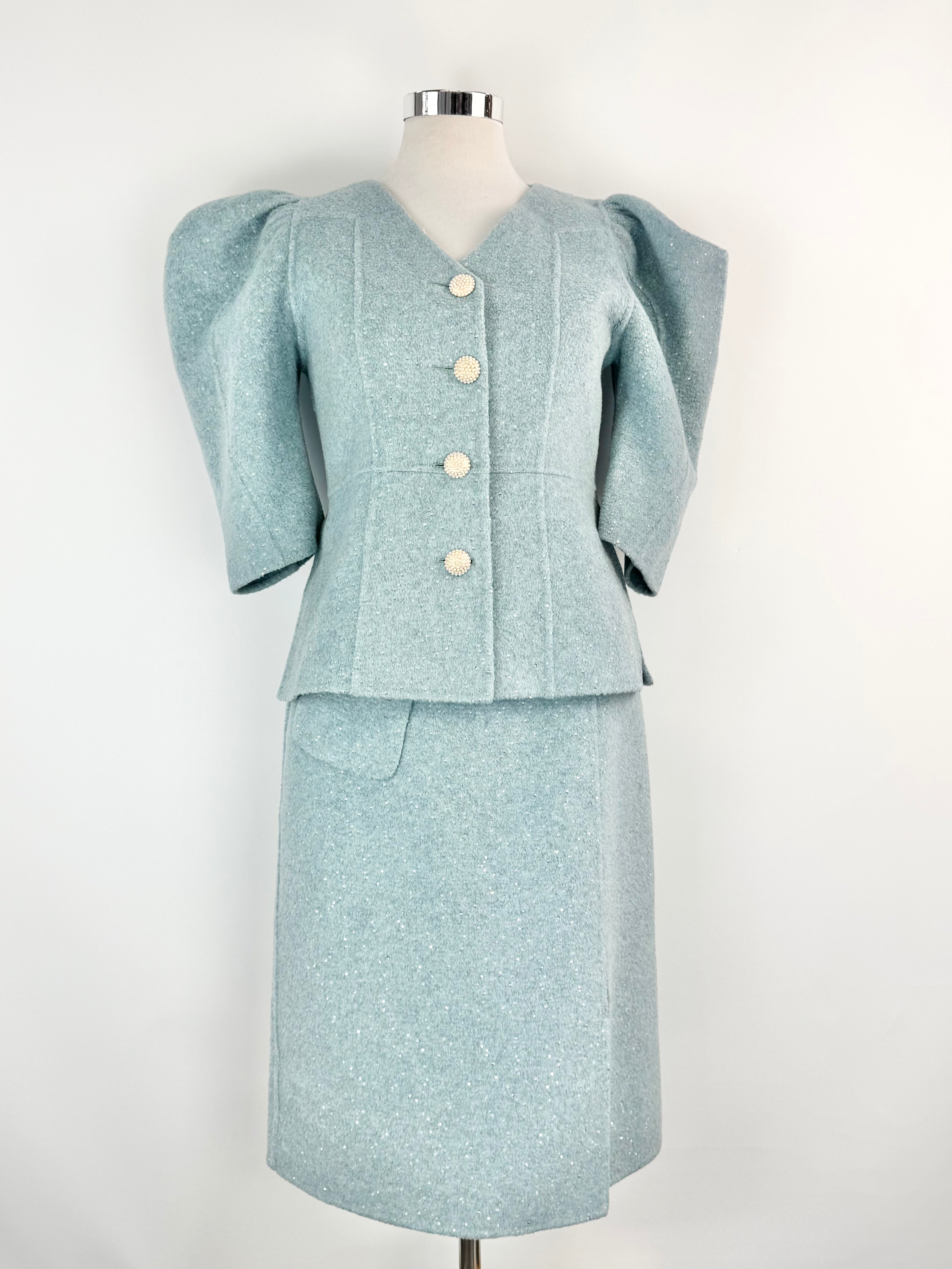 Light blue suit with puffed sleeves on a mannequin against a white background