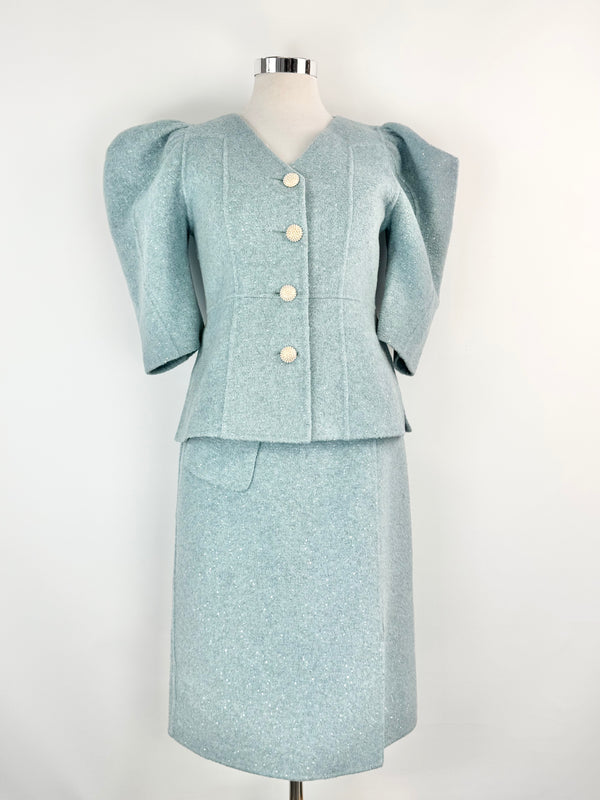 Light blue suit with puffed sleeves on a mannequin against a white background