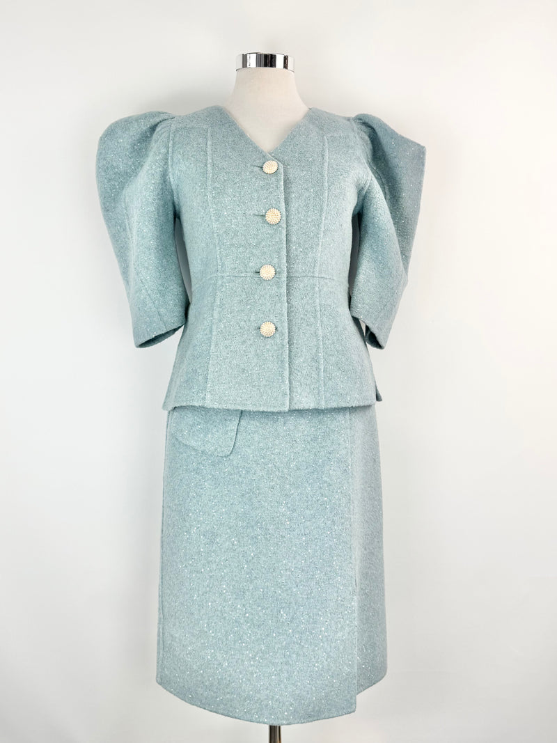 Light blue suit with puffed sleeves on a mannequin against a white background