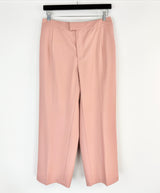 Pink pants hanging on a rack against a white background