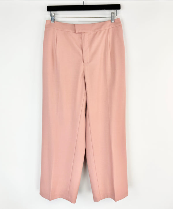 Pink pants hanging on a rack against a white background