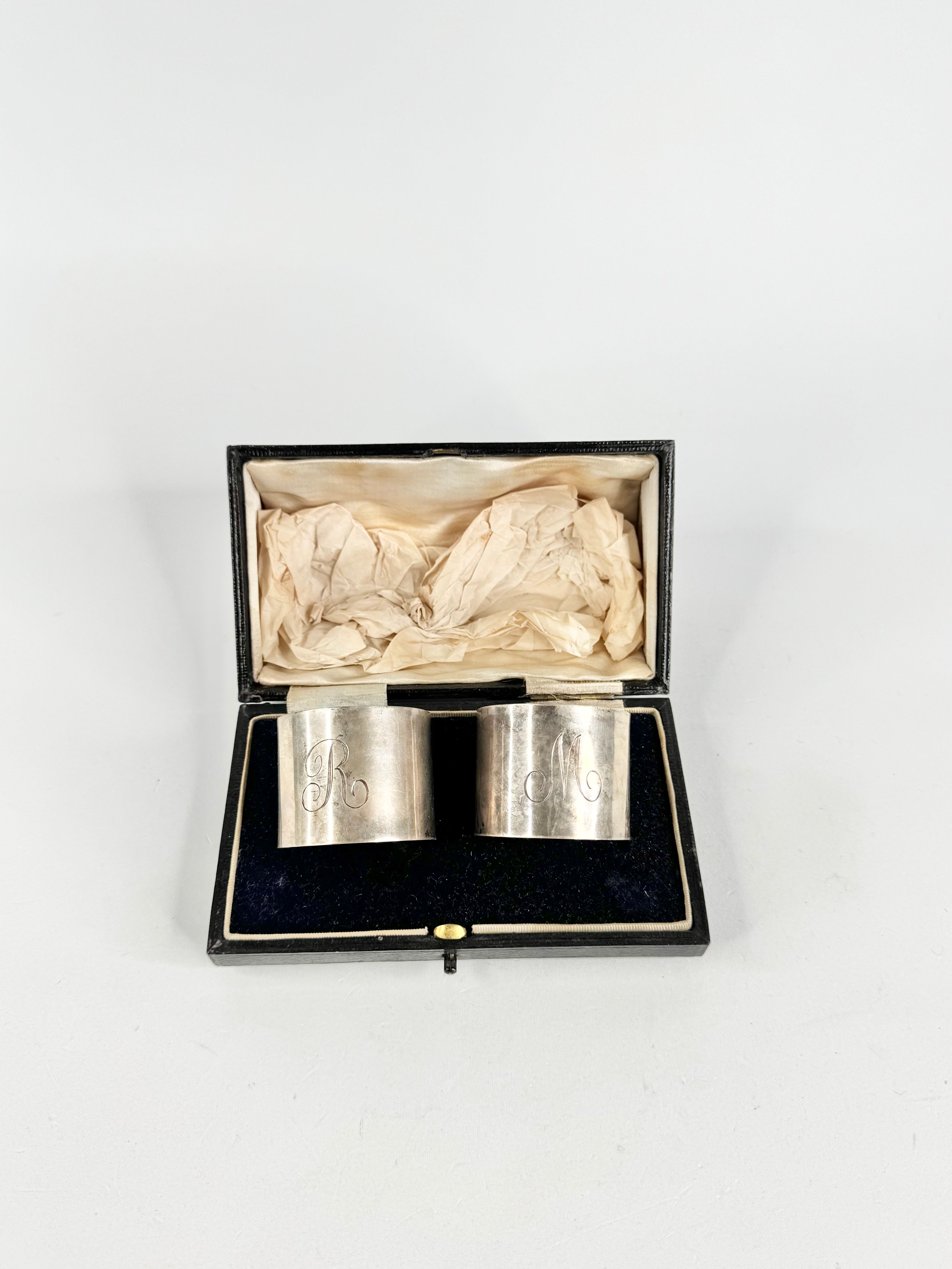 Silver napkin holders in a black box on a white background