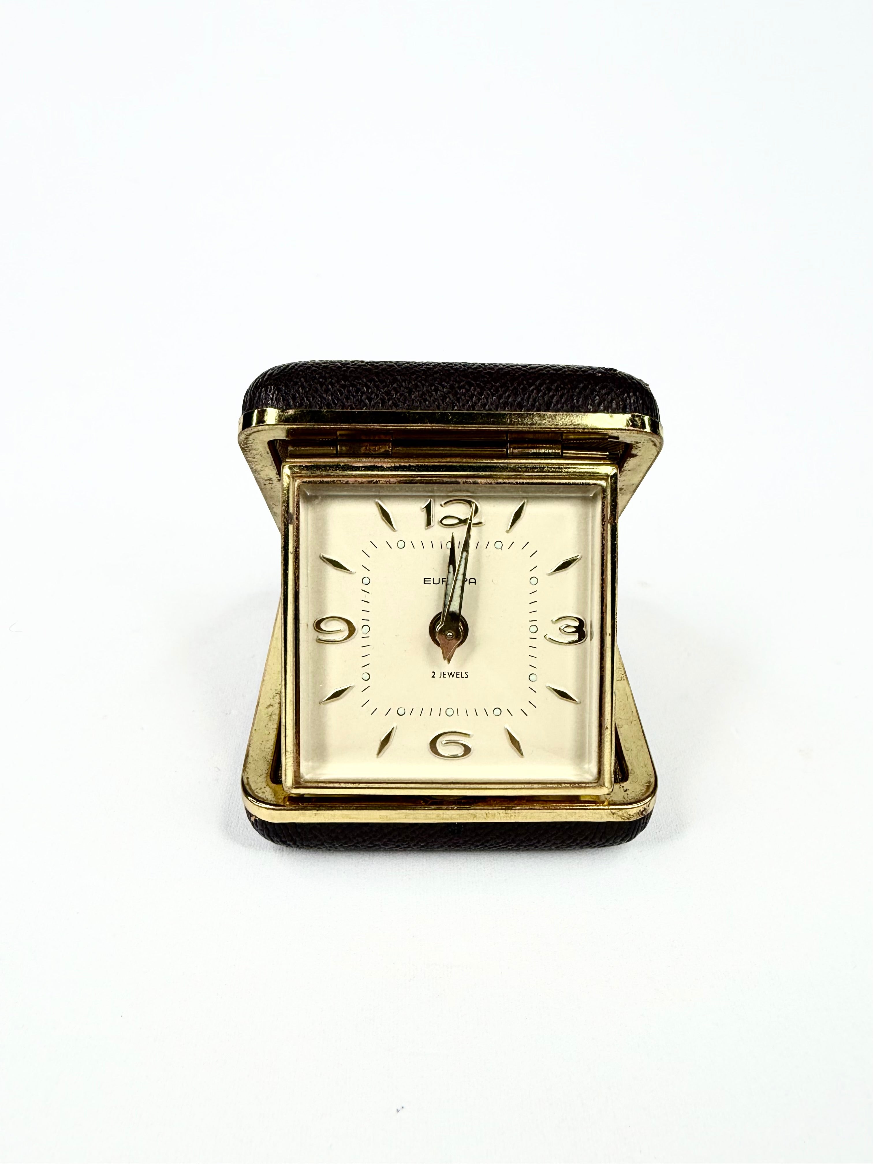 Vintage gold wristwatch with black band on a white background