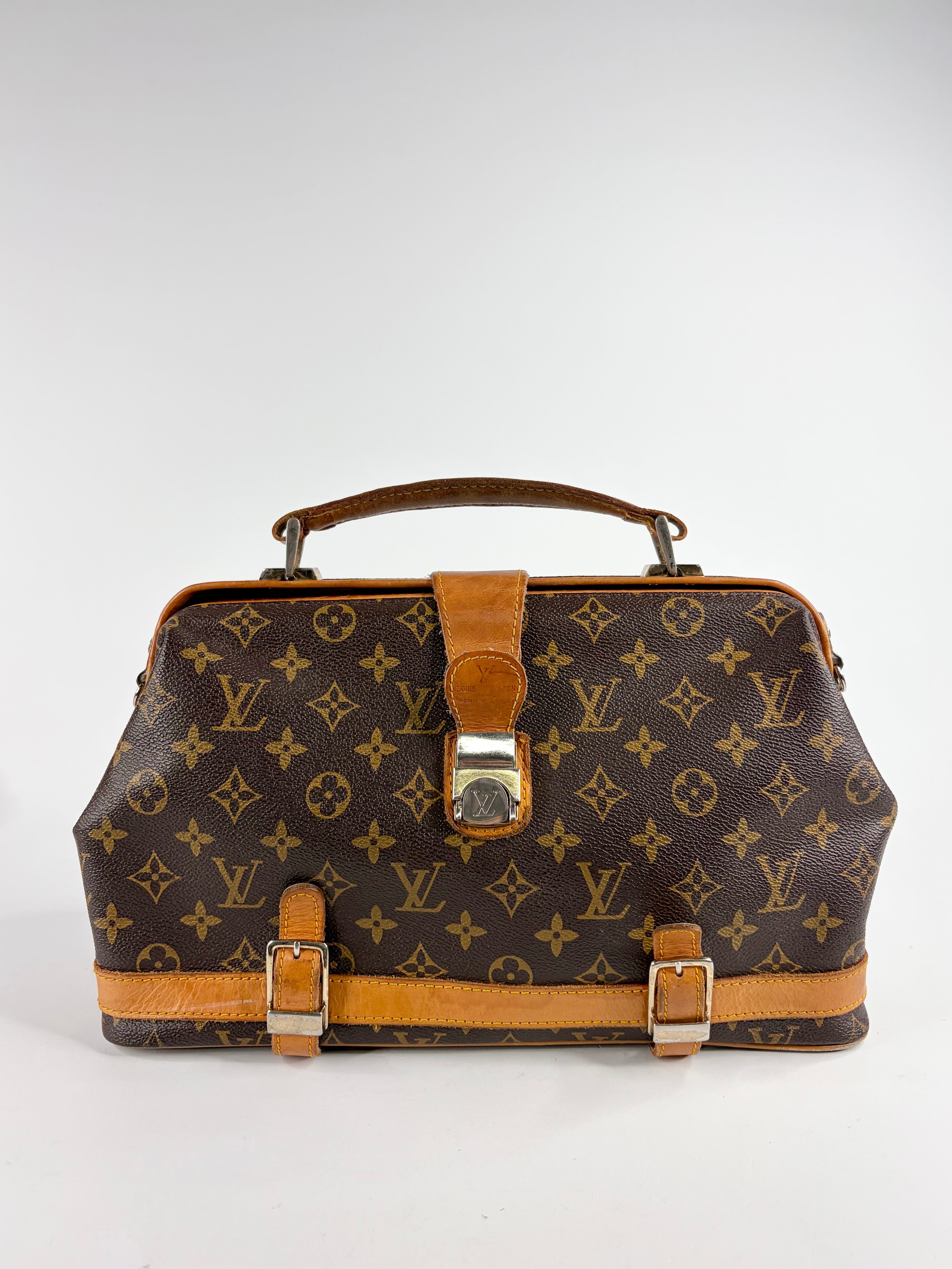Brown handbag with monogram pattern on a white background