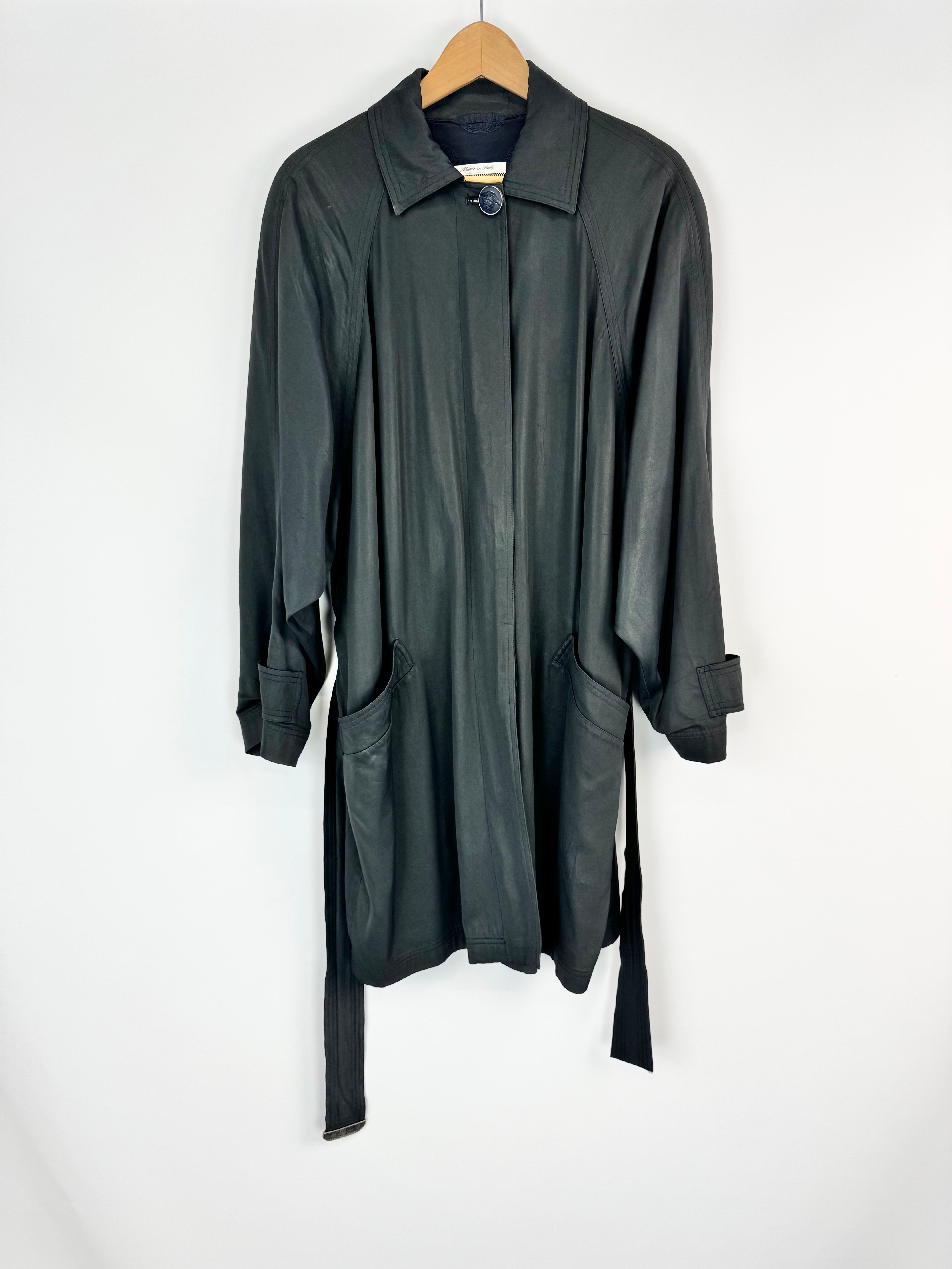 Black coat on a hanger against a white background