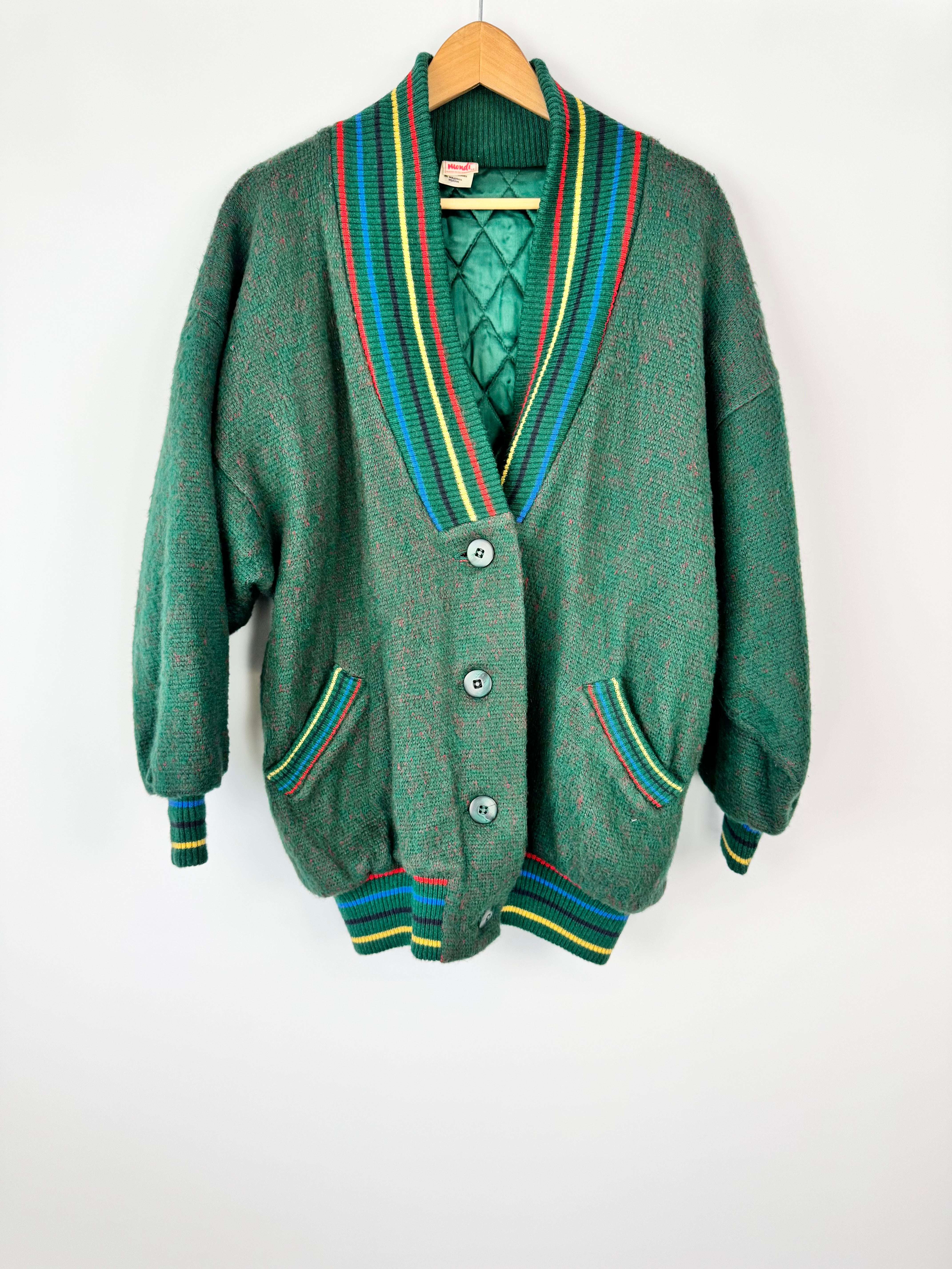 Green cardigan with colorful trim on a white background