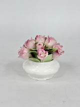 Small white vase with pink roses on a light gray background