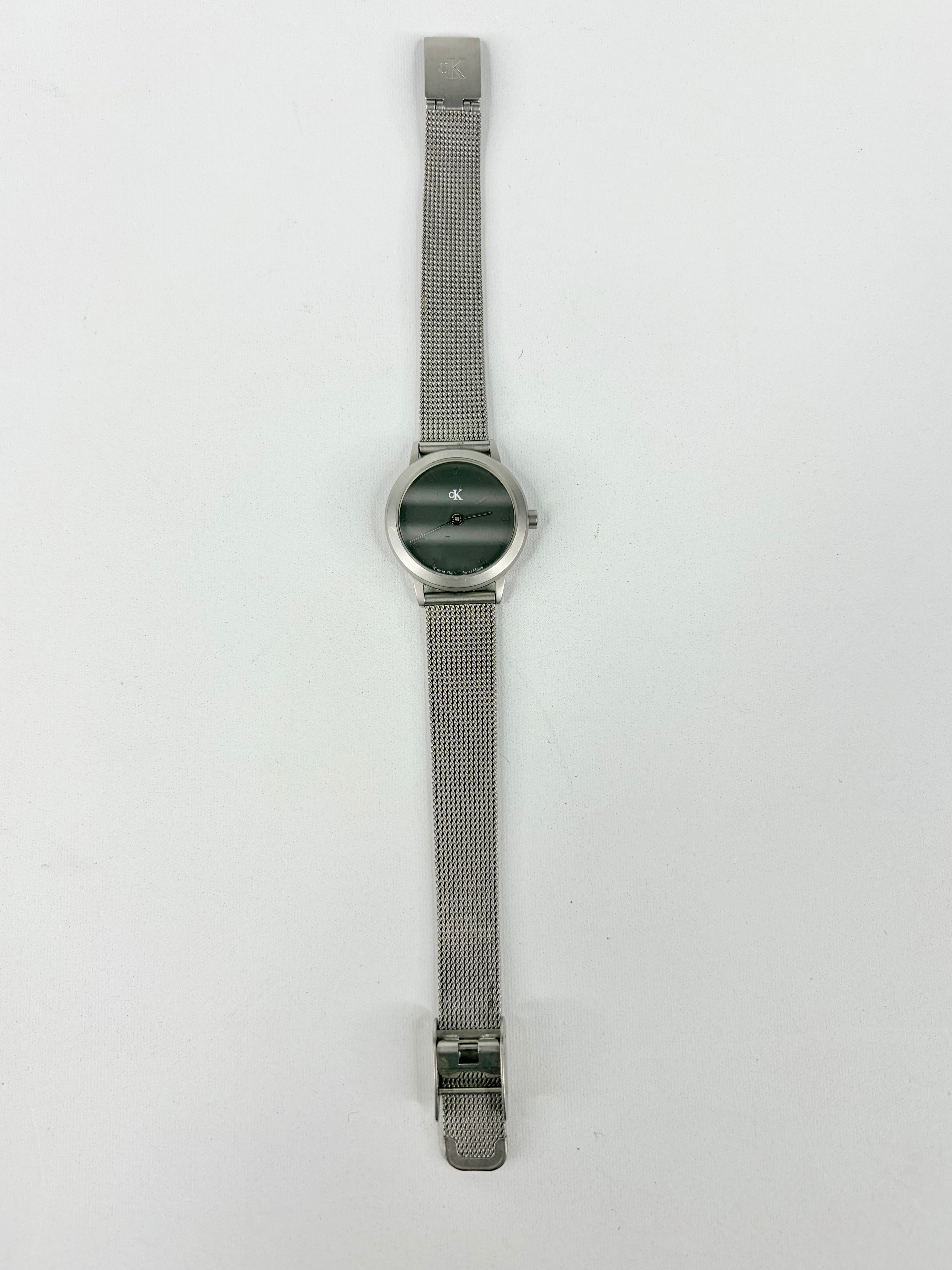 Silver watch with mesh band on a white background