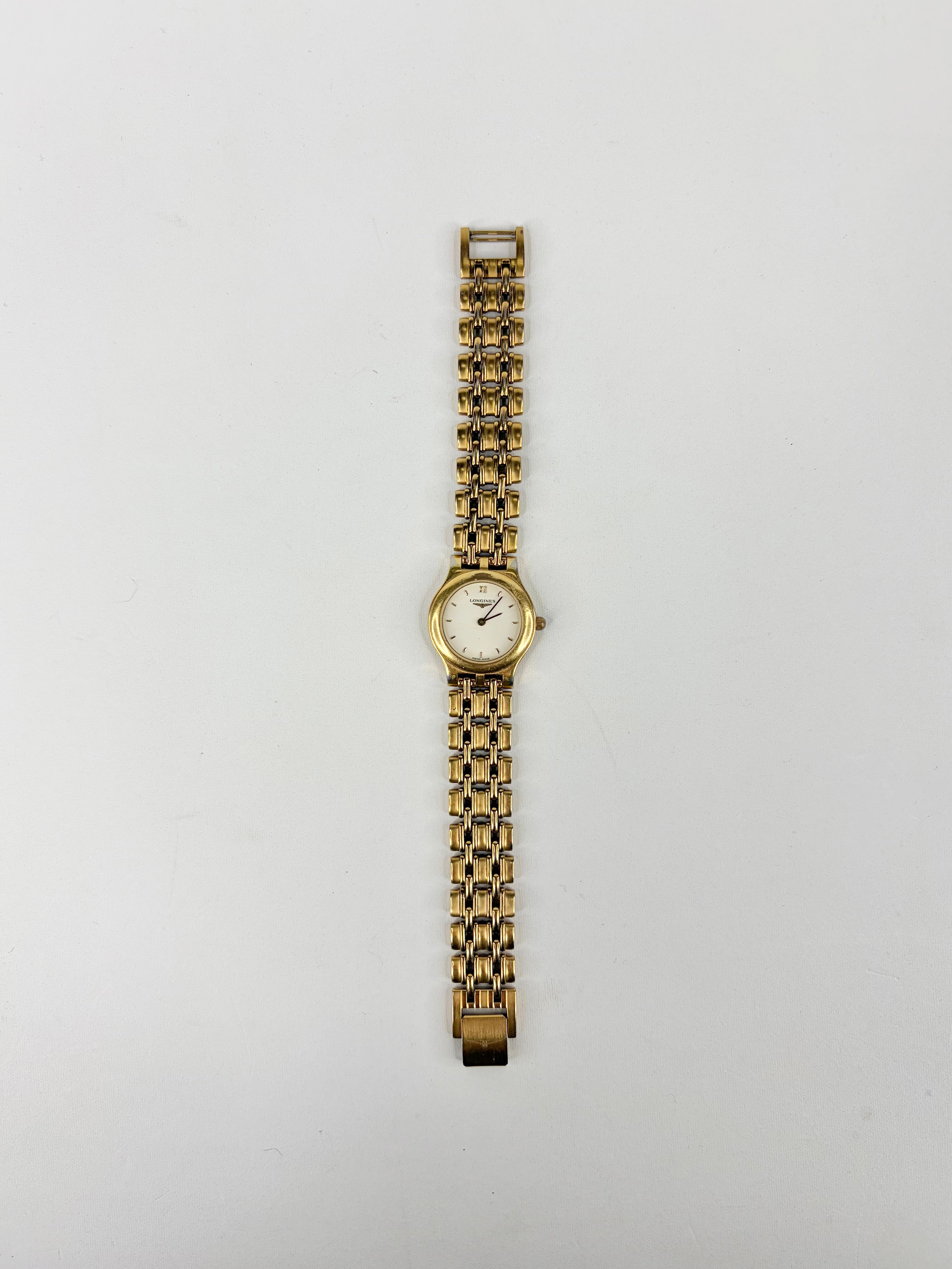 Gold watch with a chain-like bracelet on a white background