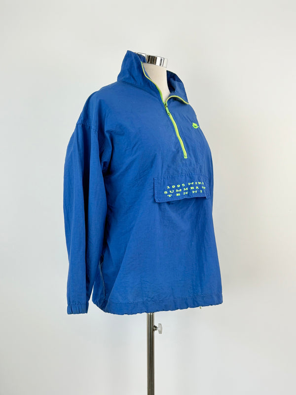 A vintage '95 Nike 'Summer of Tennis' 1/2 Zip Jacket in blue color displayed on a mannequin. The jacket has a zipper, a hood, and a front pocket with a visible brand logo.