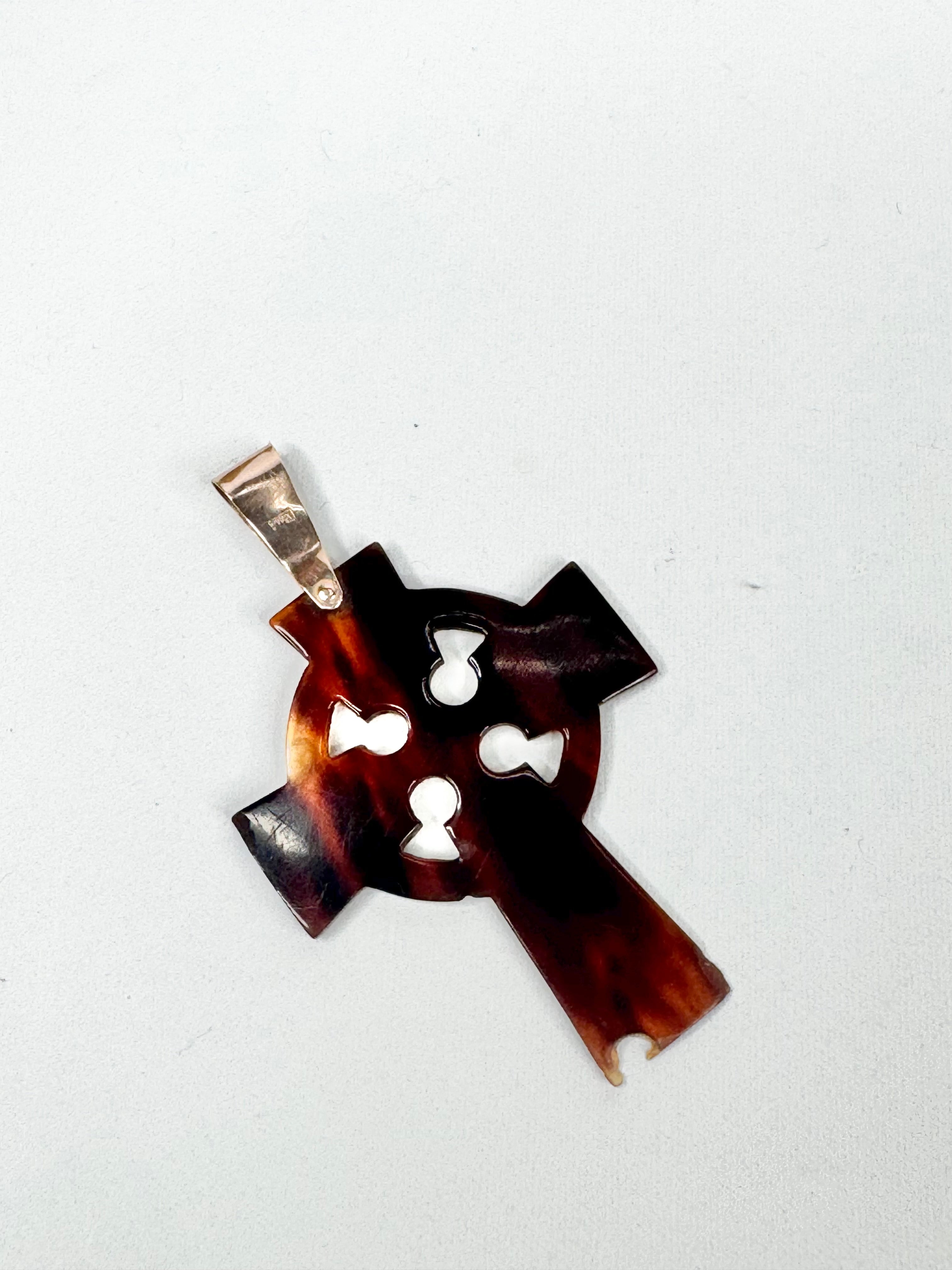 Brown cross-shaped pendant with gold accent on a white background