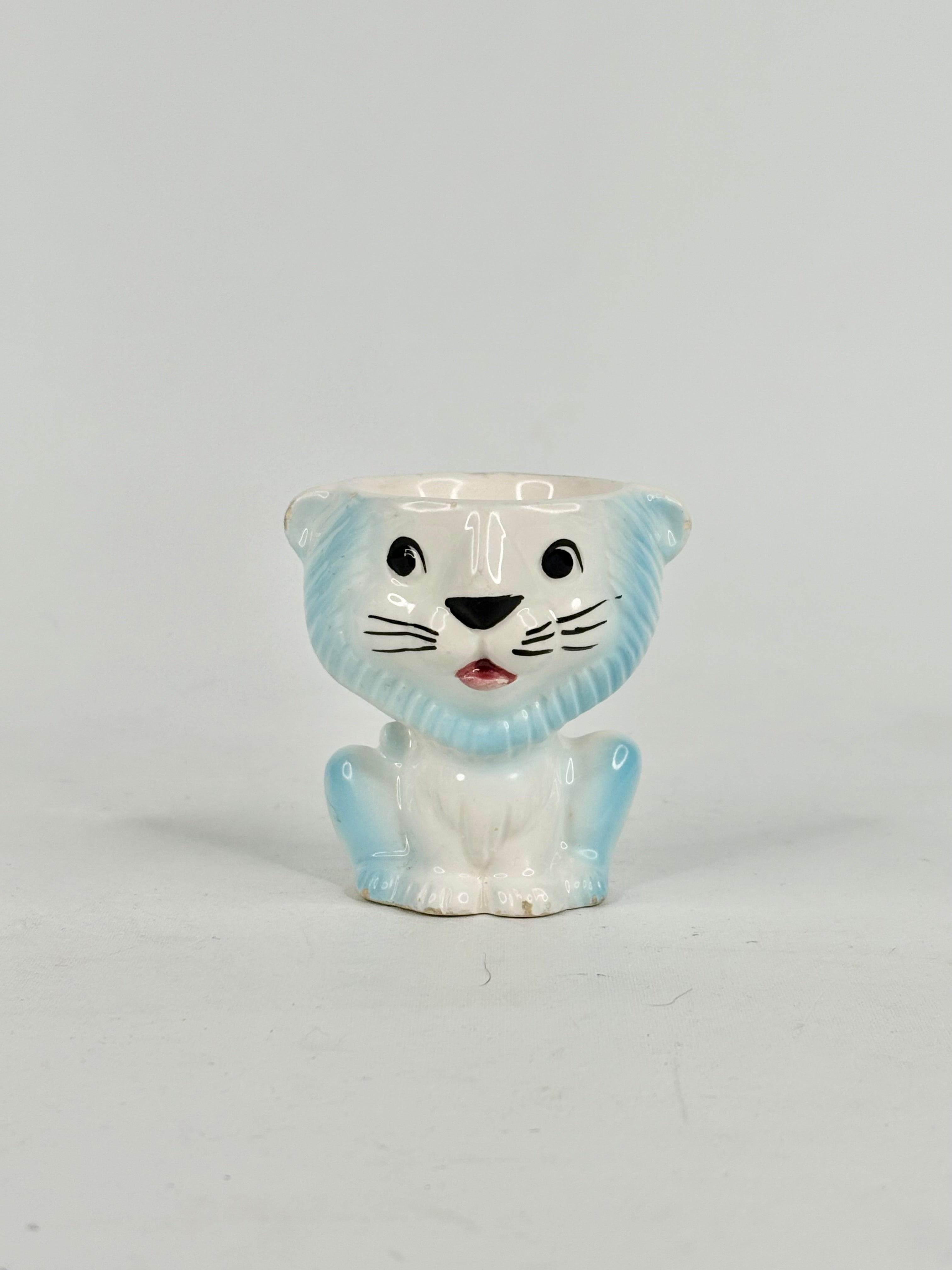 White ceramic tiger planter with blue accents on a light gray background