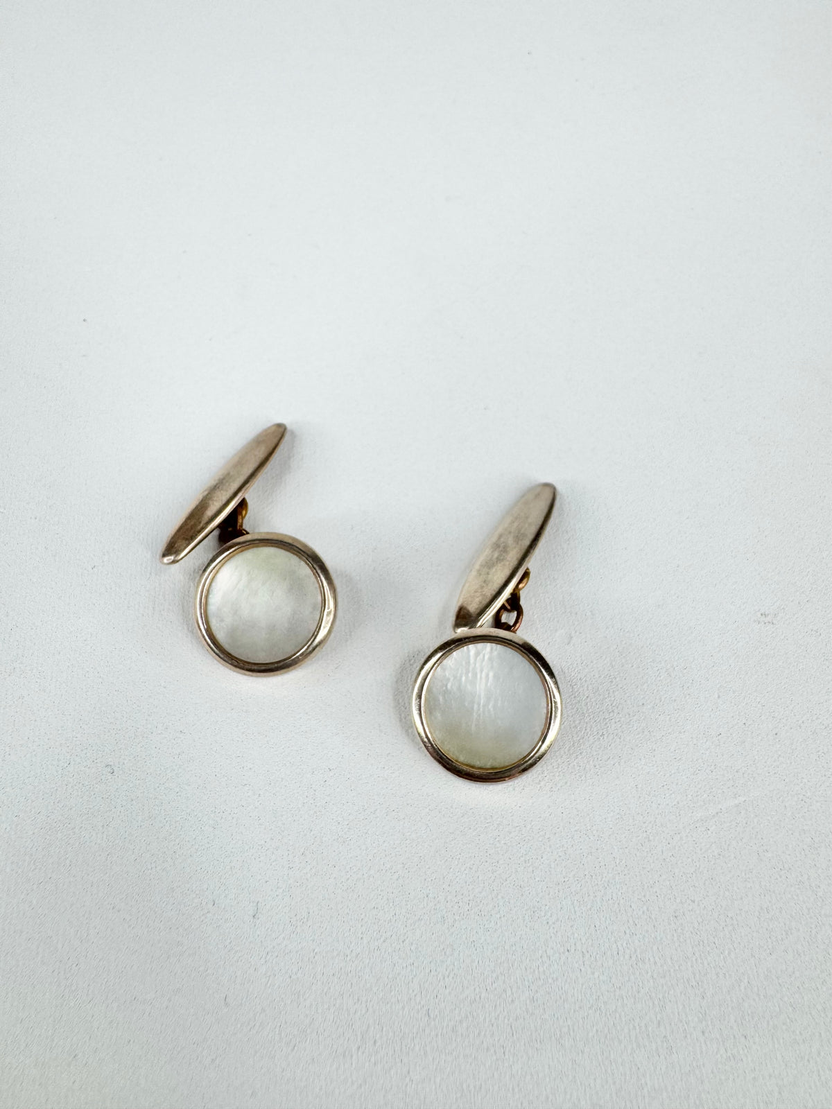 Pair of silver earrings with round gemstones on a white background