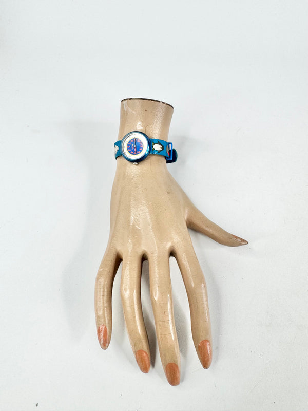 Mannequin hand wearing a blue bracelet with a circular design on a white background