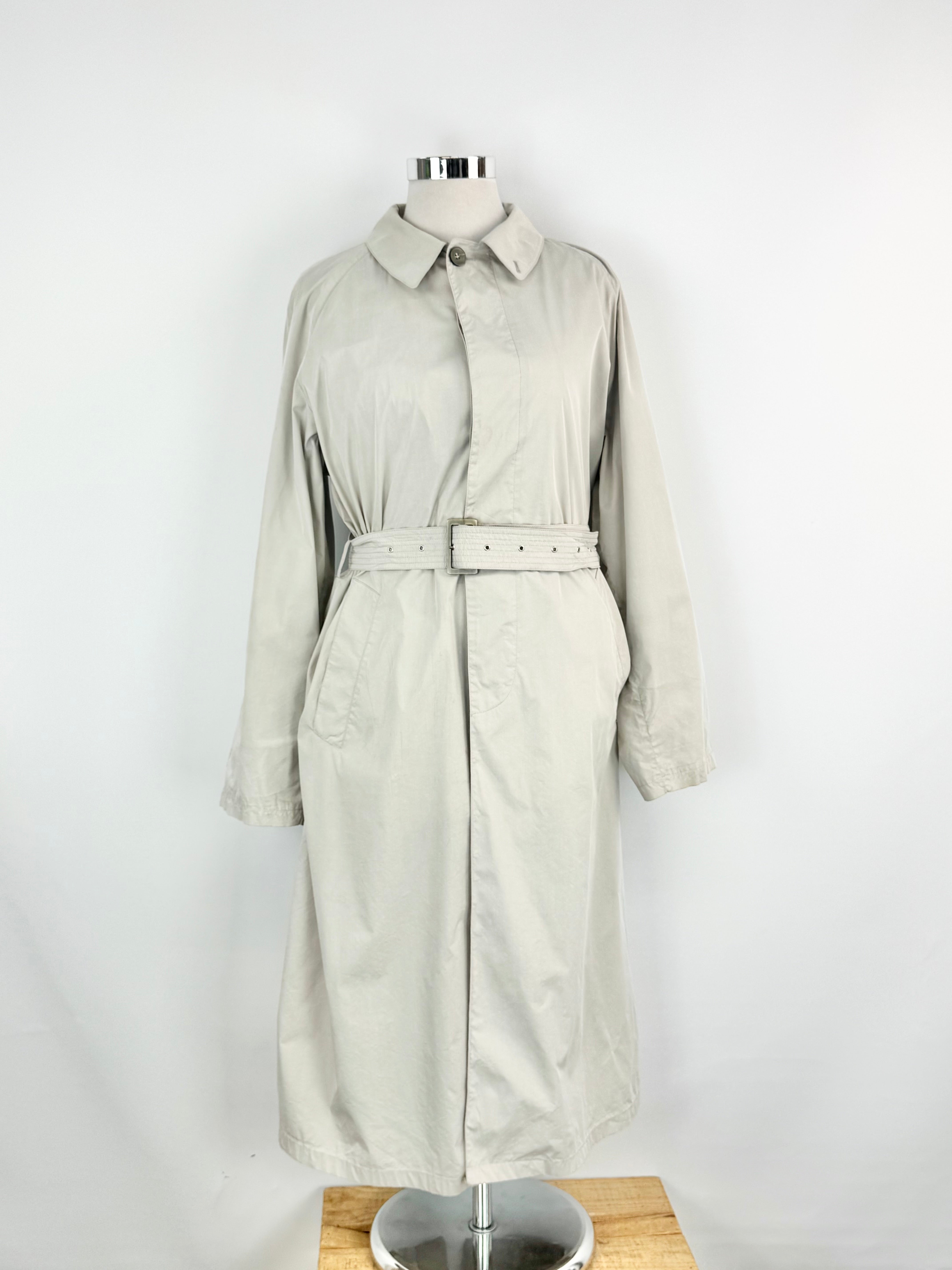 Beige trench coat on a mannequin against a white background