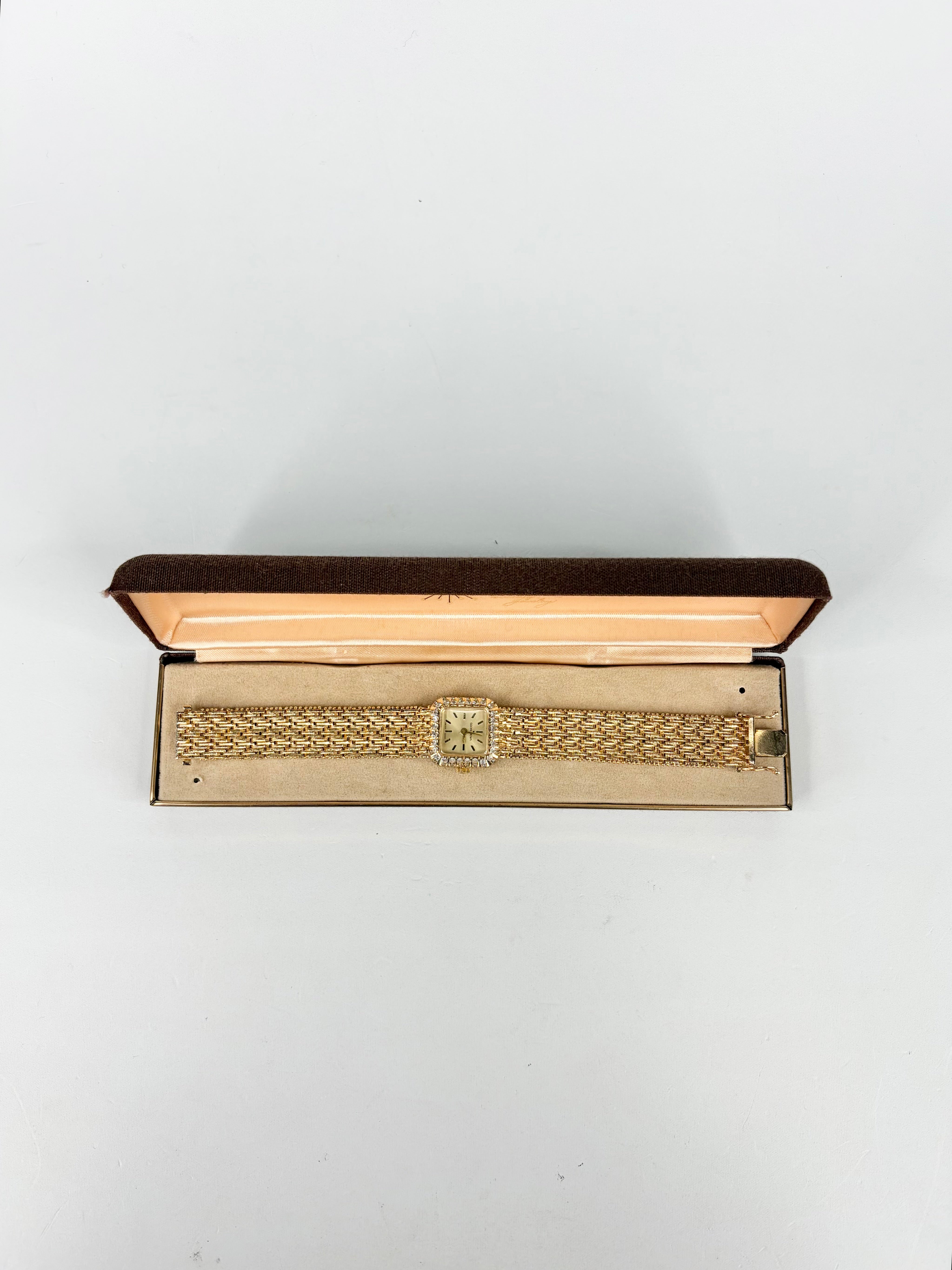 Gold jewelry box with intricate design on a white background