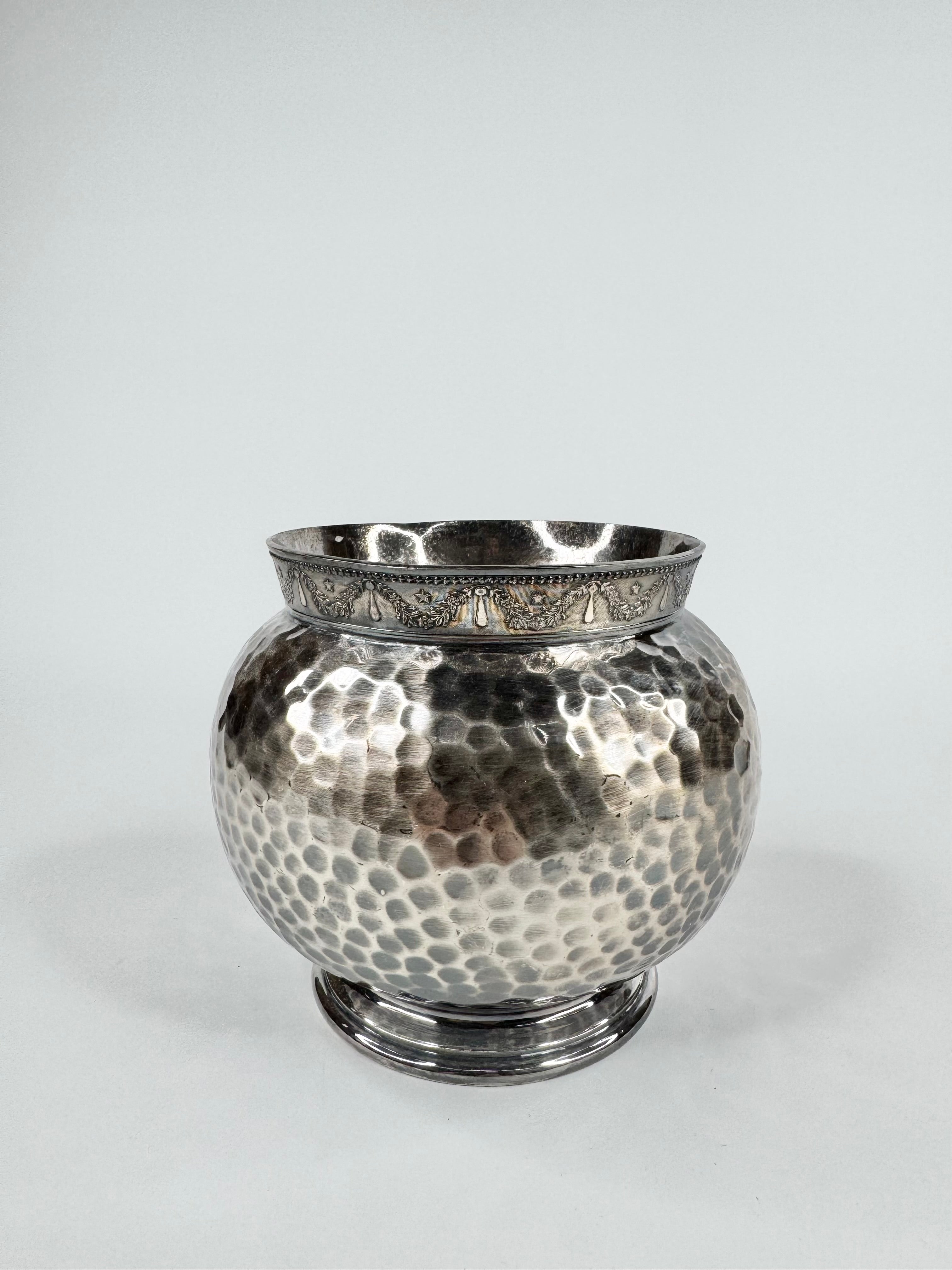 Silver vase with textured surface on a white background