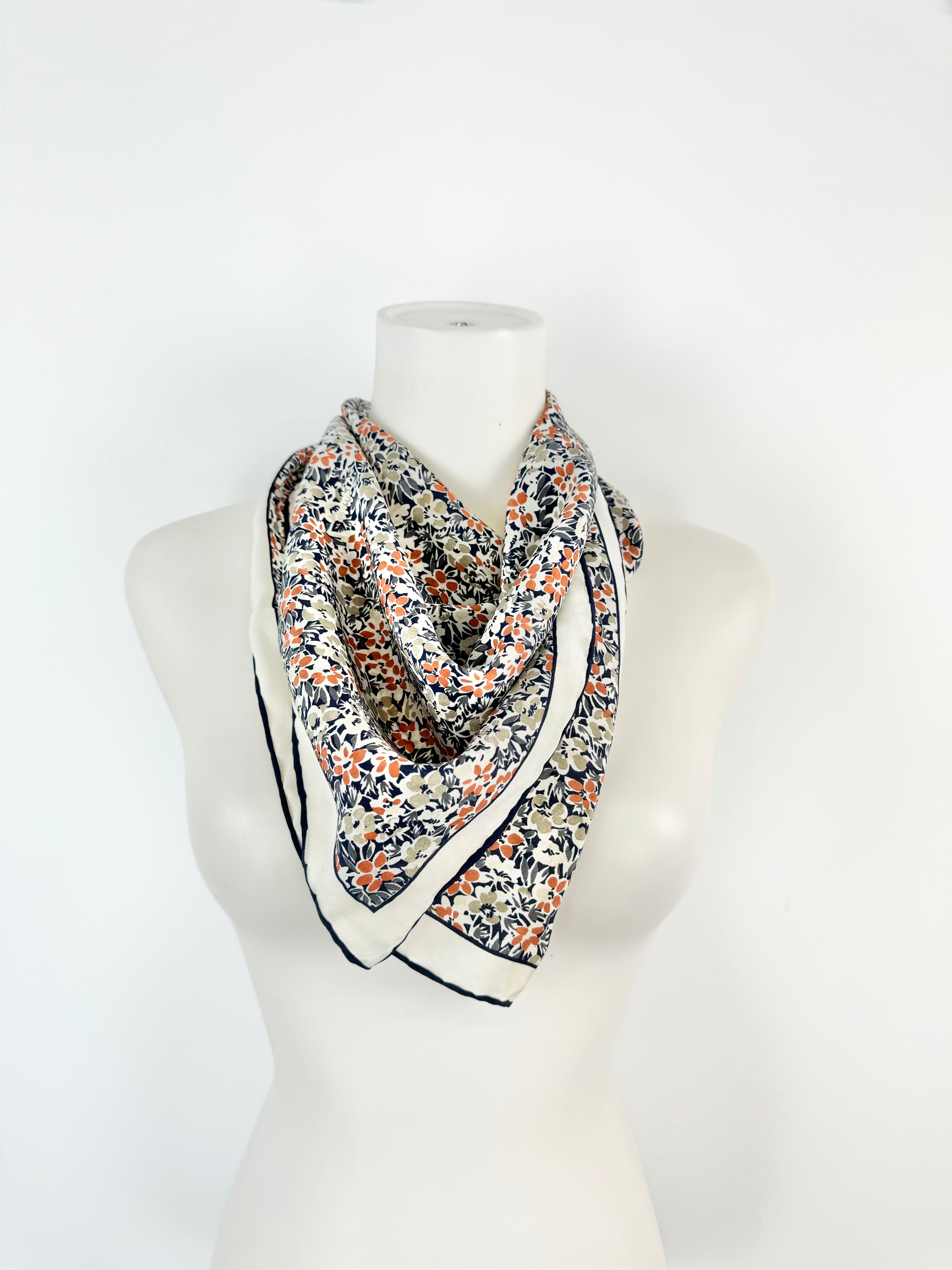Floral patterned scarf on a mannequin against a white background