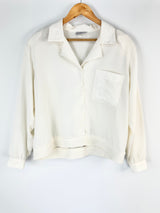 White blouse on a wooden hanger against a white background