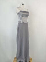 A vintage Mariana Hardwick silver dress displayed on a mannequin, consisting of a crop top and a maxi skirt.