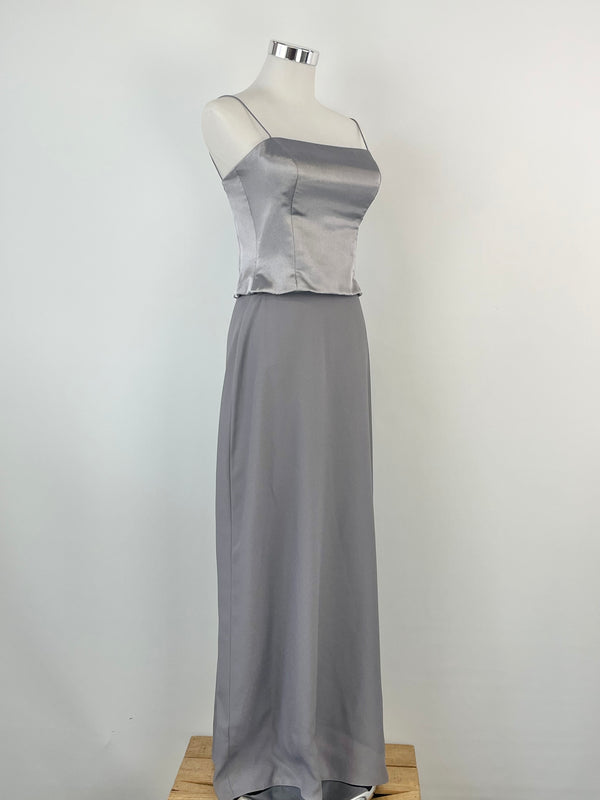 A vintage Mariana Hardwick silver dress displayed on a mannequin, consisting of a crop top and a maxi skirt.