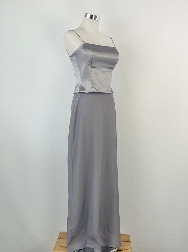 A vintage Mariana Hardwick silver dress displayed on a mannequin, consisting of a crop top and a maxi skirt.