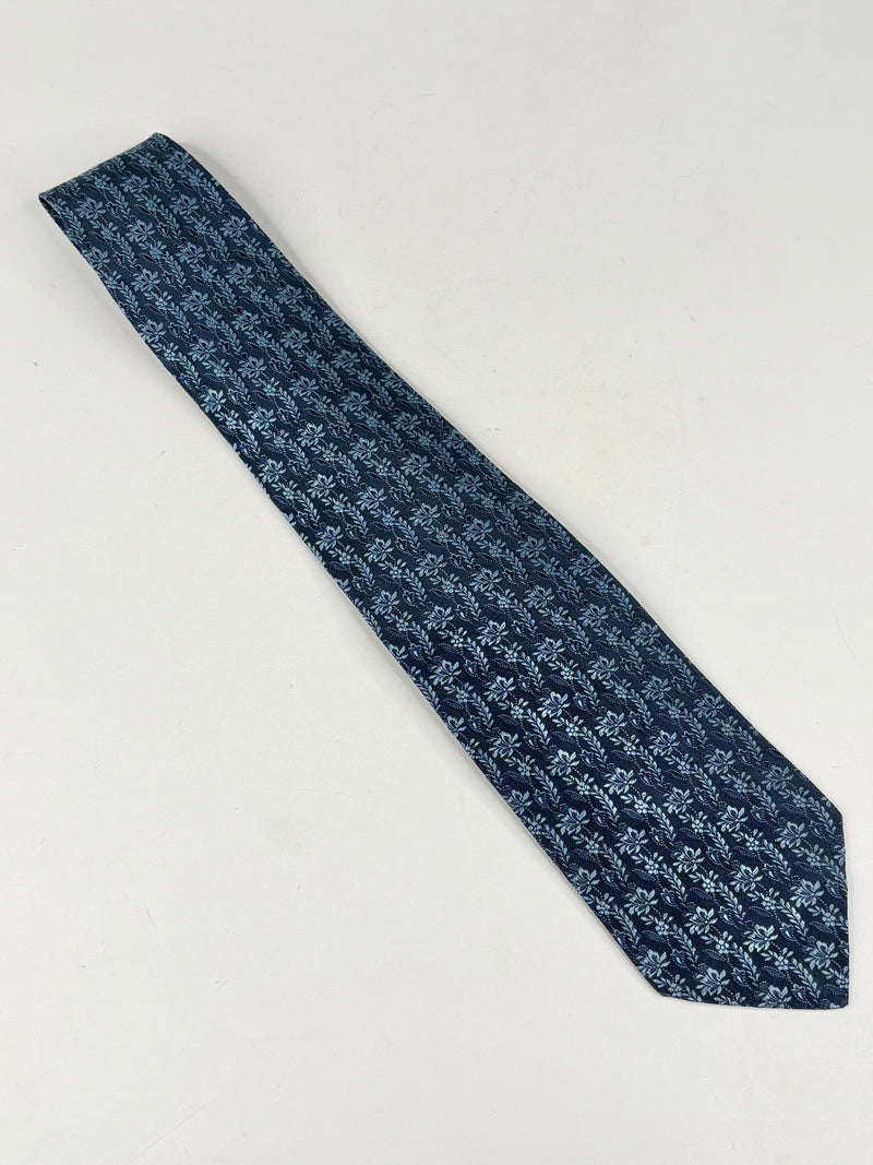 Blue patterned tie on a light gray background