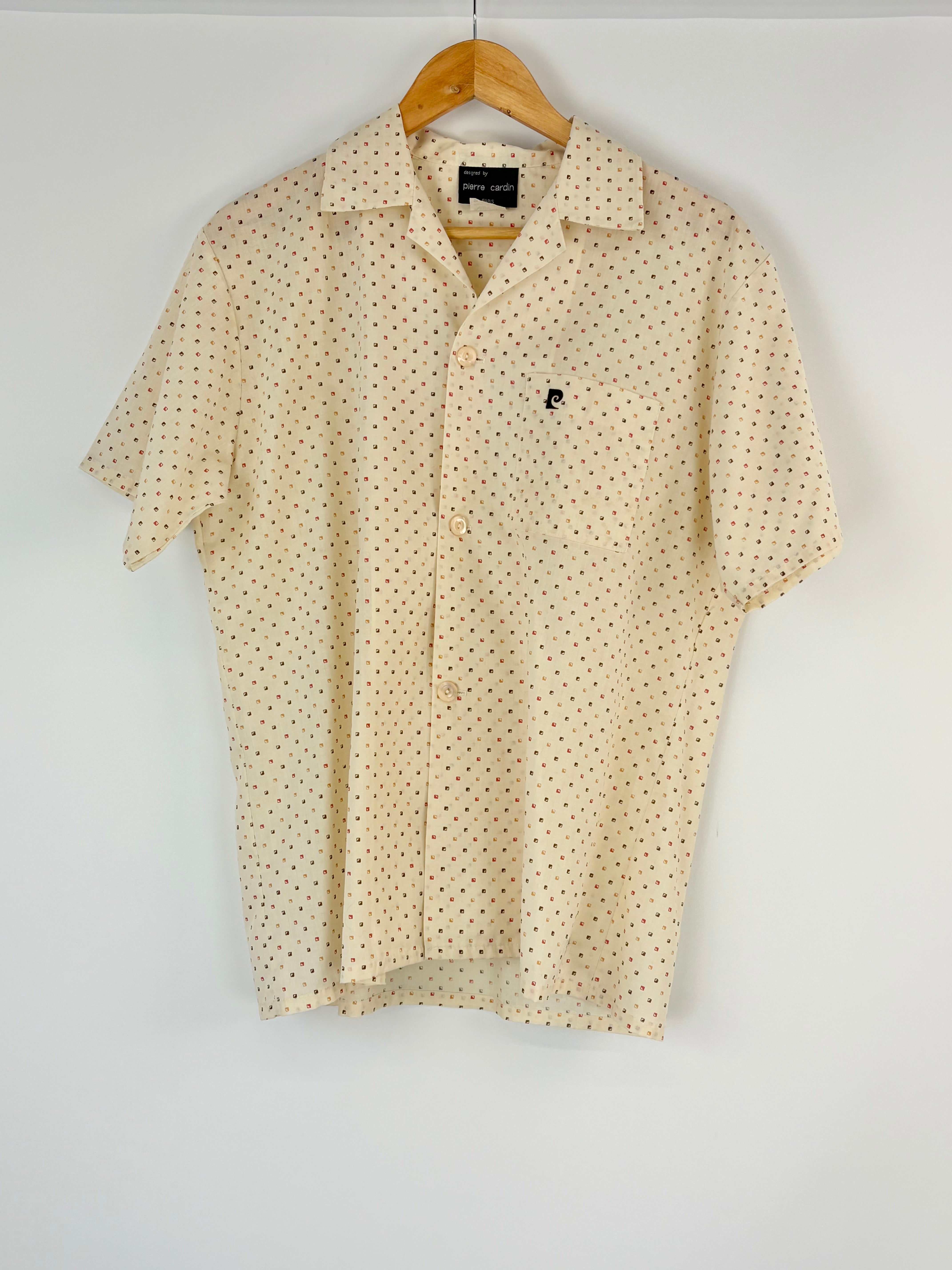 Cream short-sleeve shirt with subtle pattern on a hanger against a white background