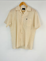 Cream short-sleeve shirt with subtle pattern on a hanger against a white background