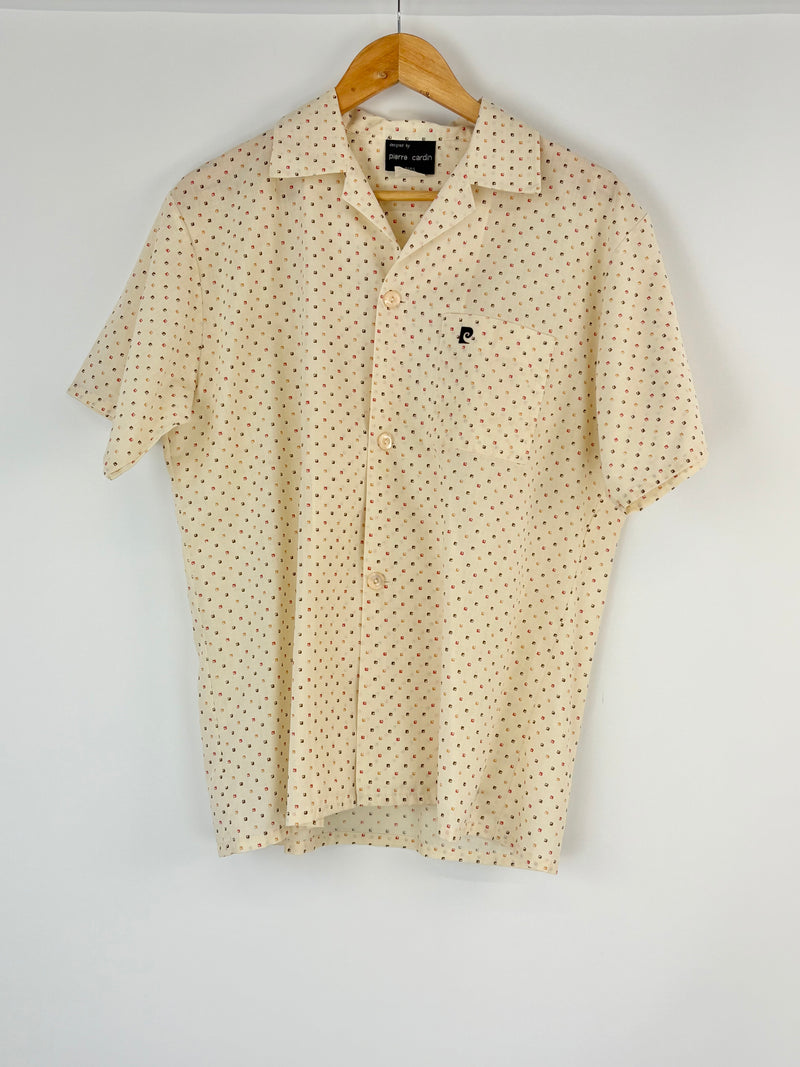 Cream short-sleeve shirt with subtle pattern on a hanger against a white background
