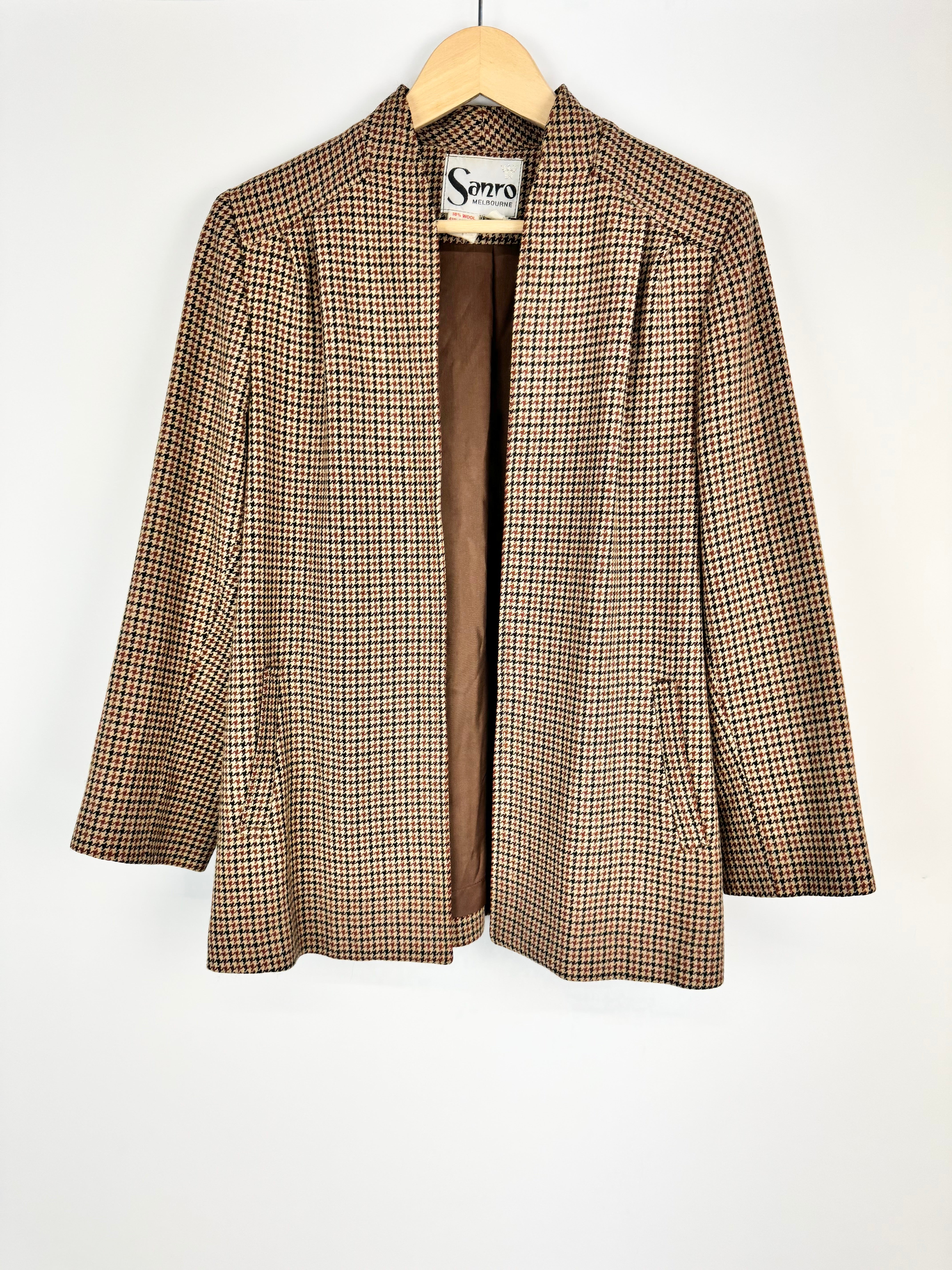 Plaid jacket on a hanger with a white background