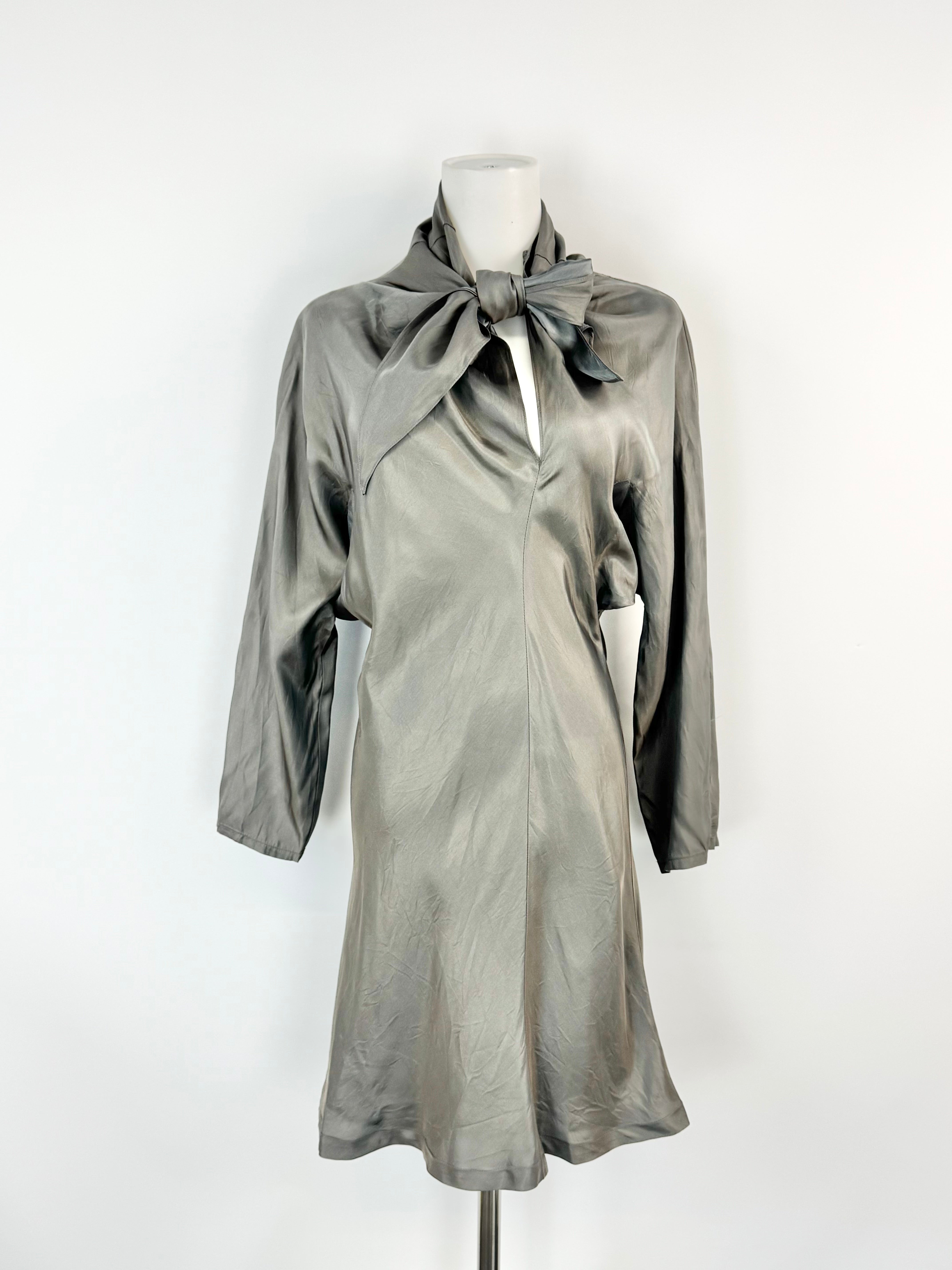Silver dress with a bow on a mannequin against a white background