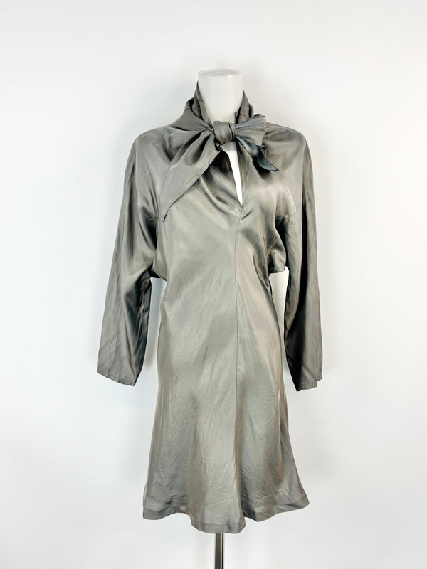 Silver dress with a bow on a mannequin against a white background