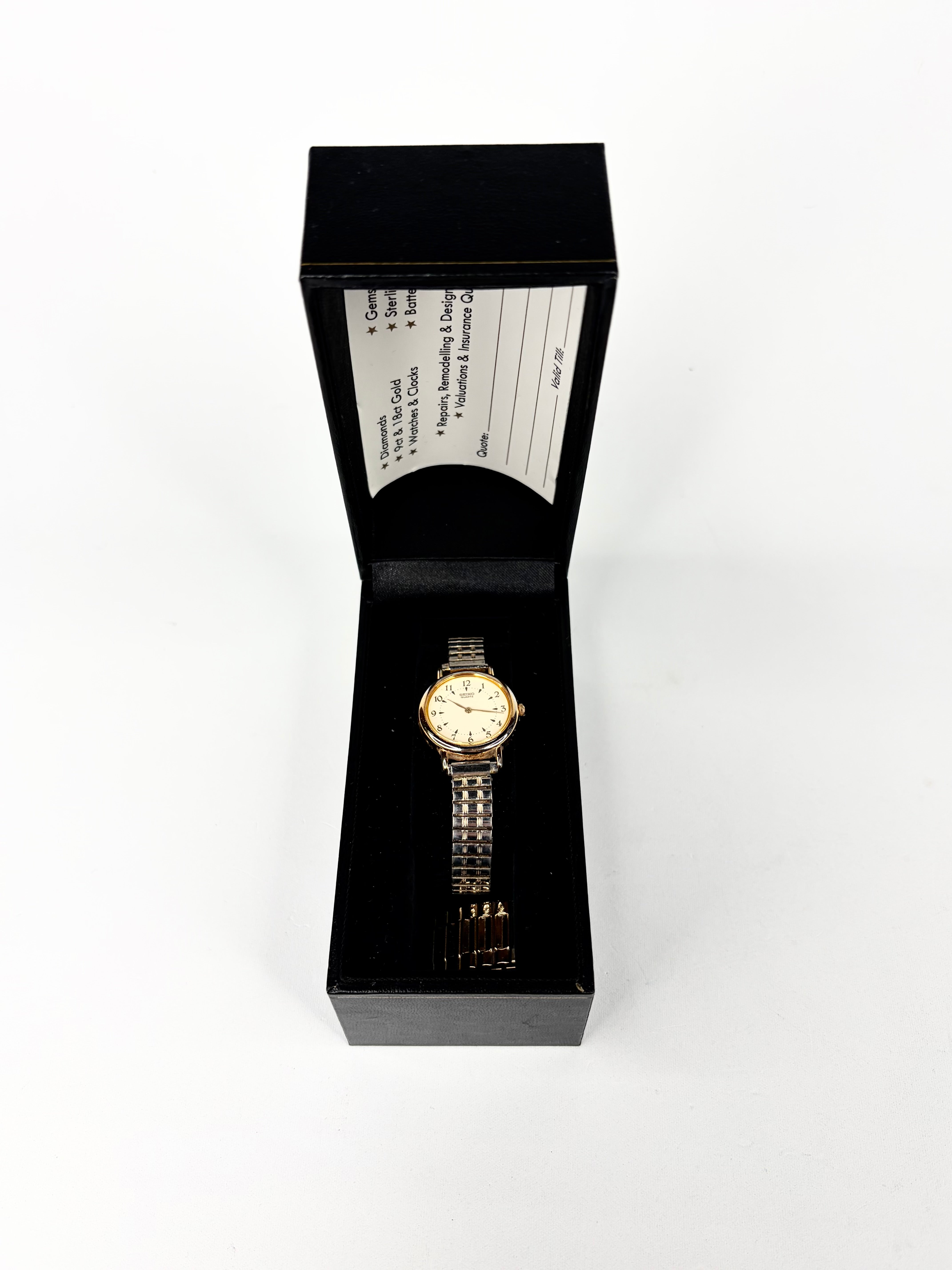 Gold watch in a black box on a white background