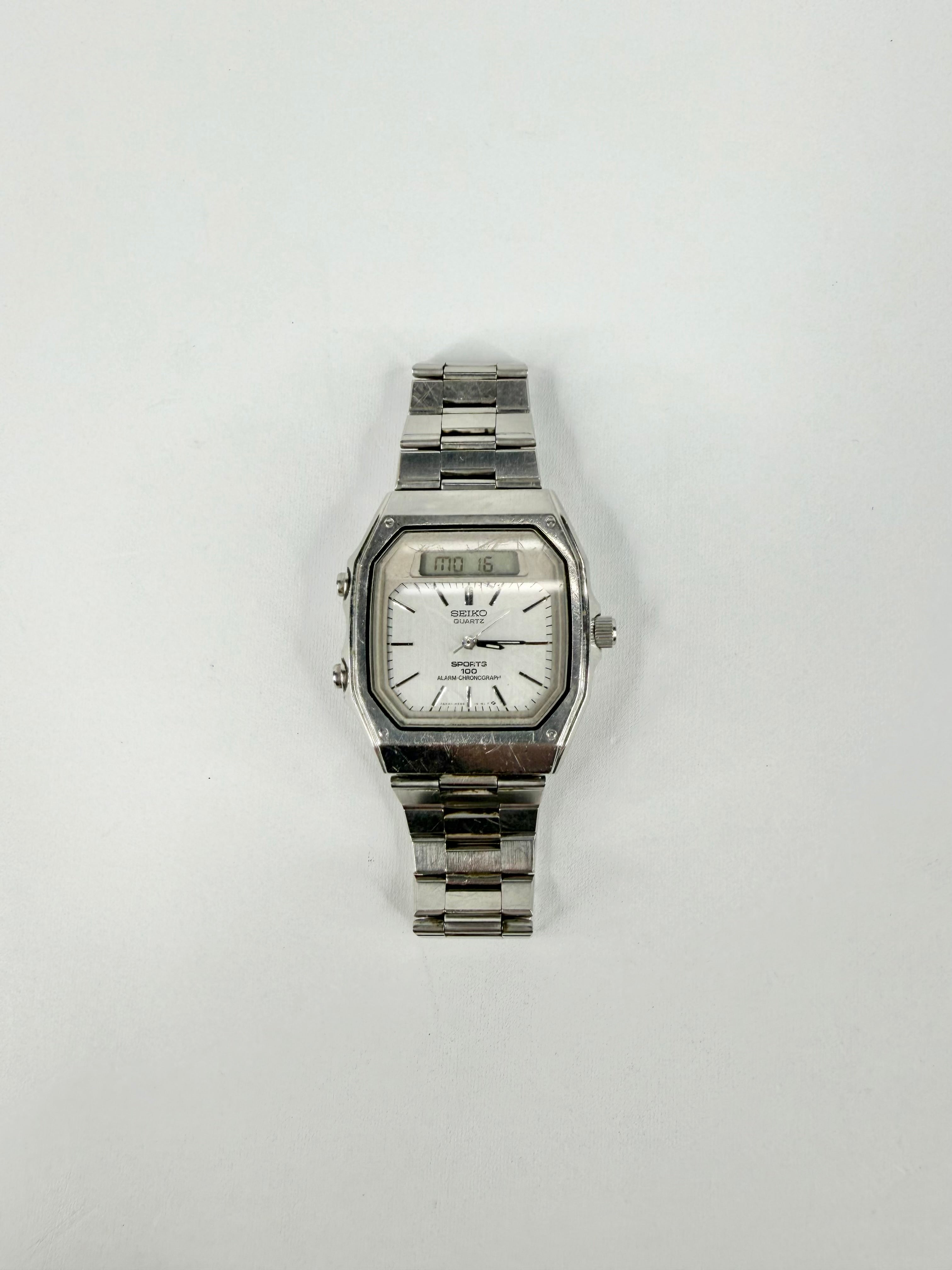 Silver wristwatch with a white face on a light gray background
