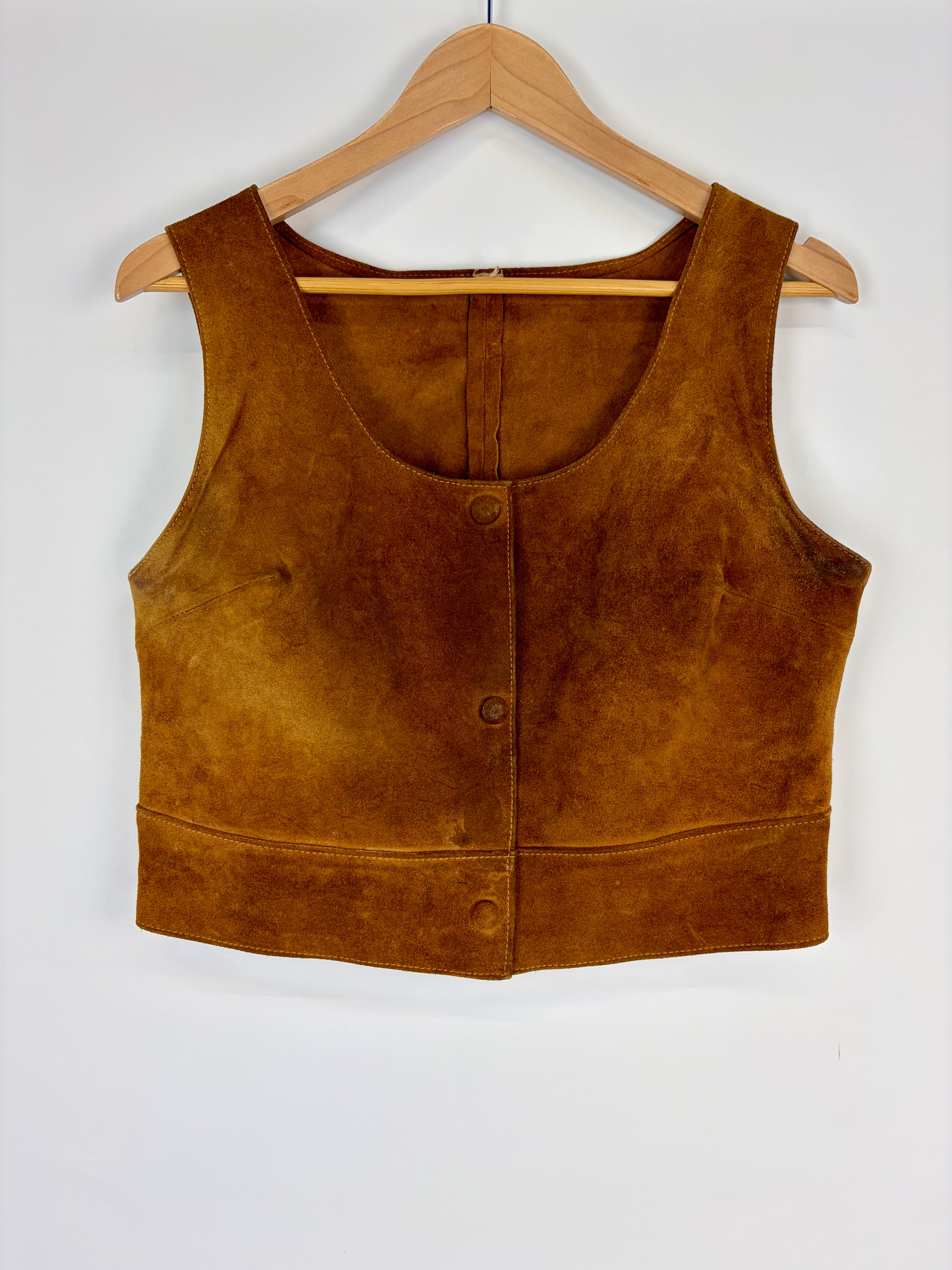 Brown suede vest on a wooden hanger against a white background