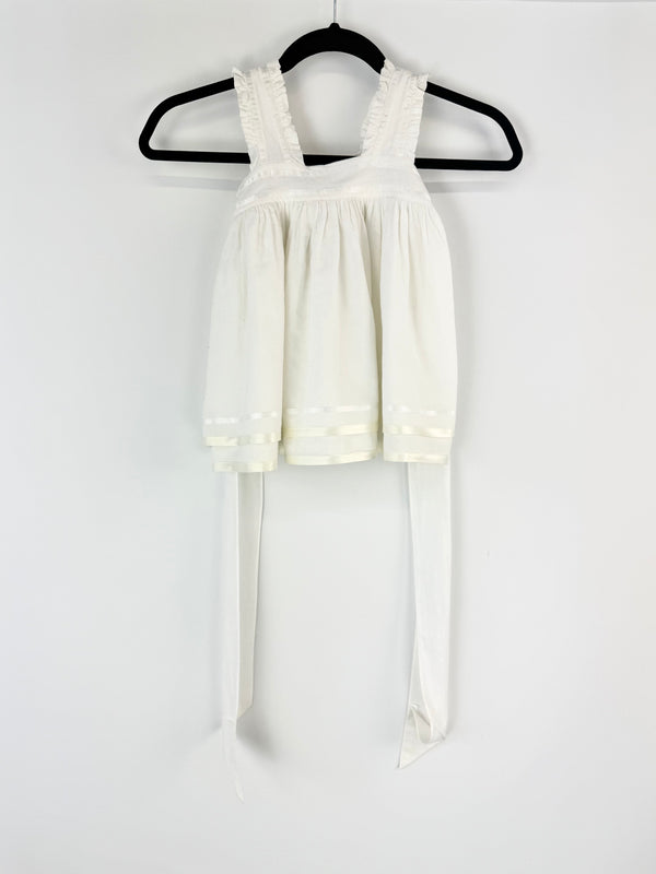 White dress with lace straps on a hanger against a white background