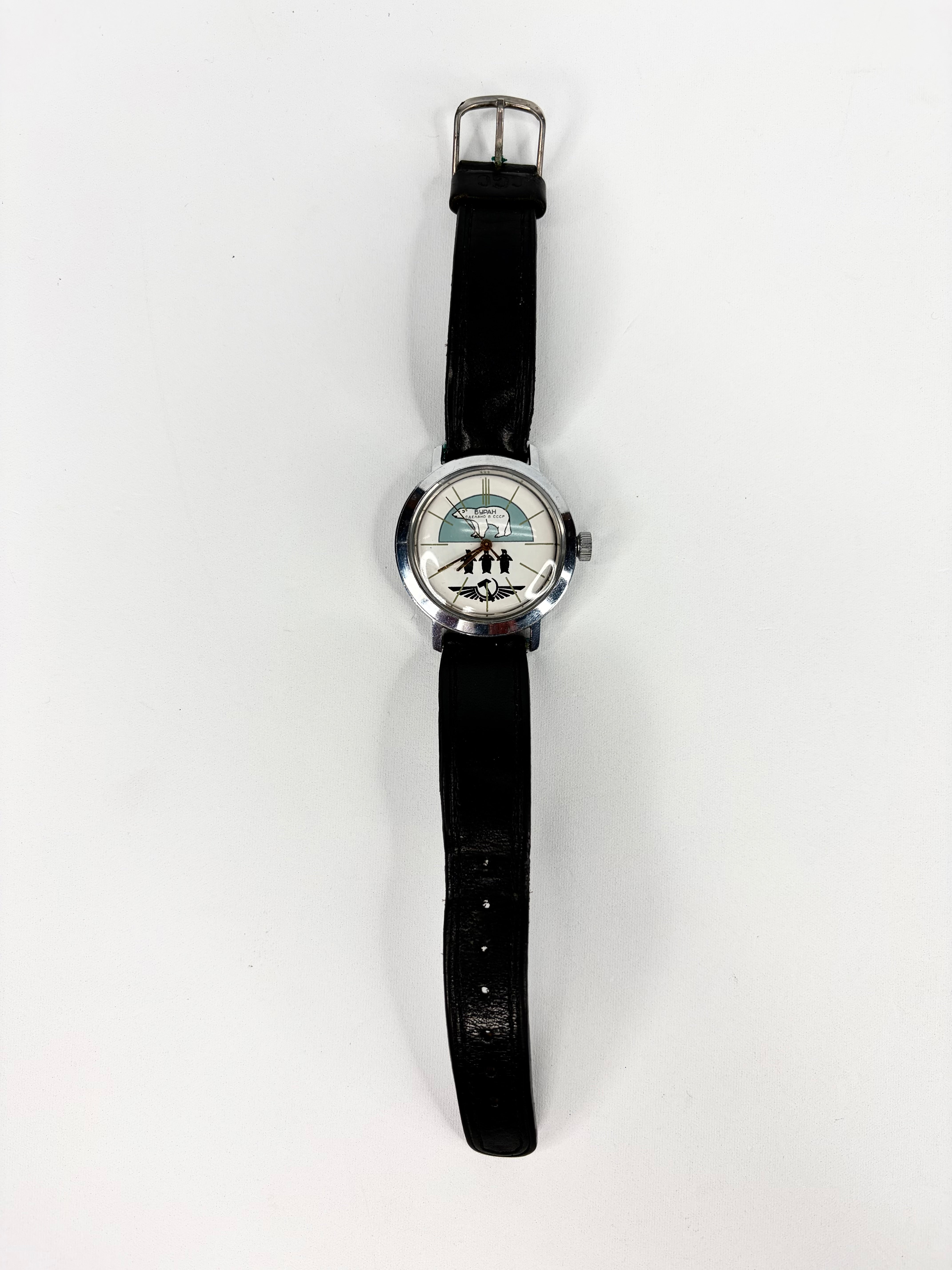 Wristwatch with black strap and decorative face on a white background