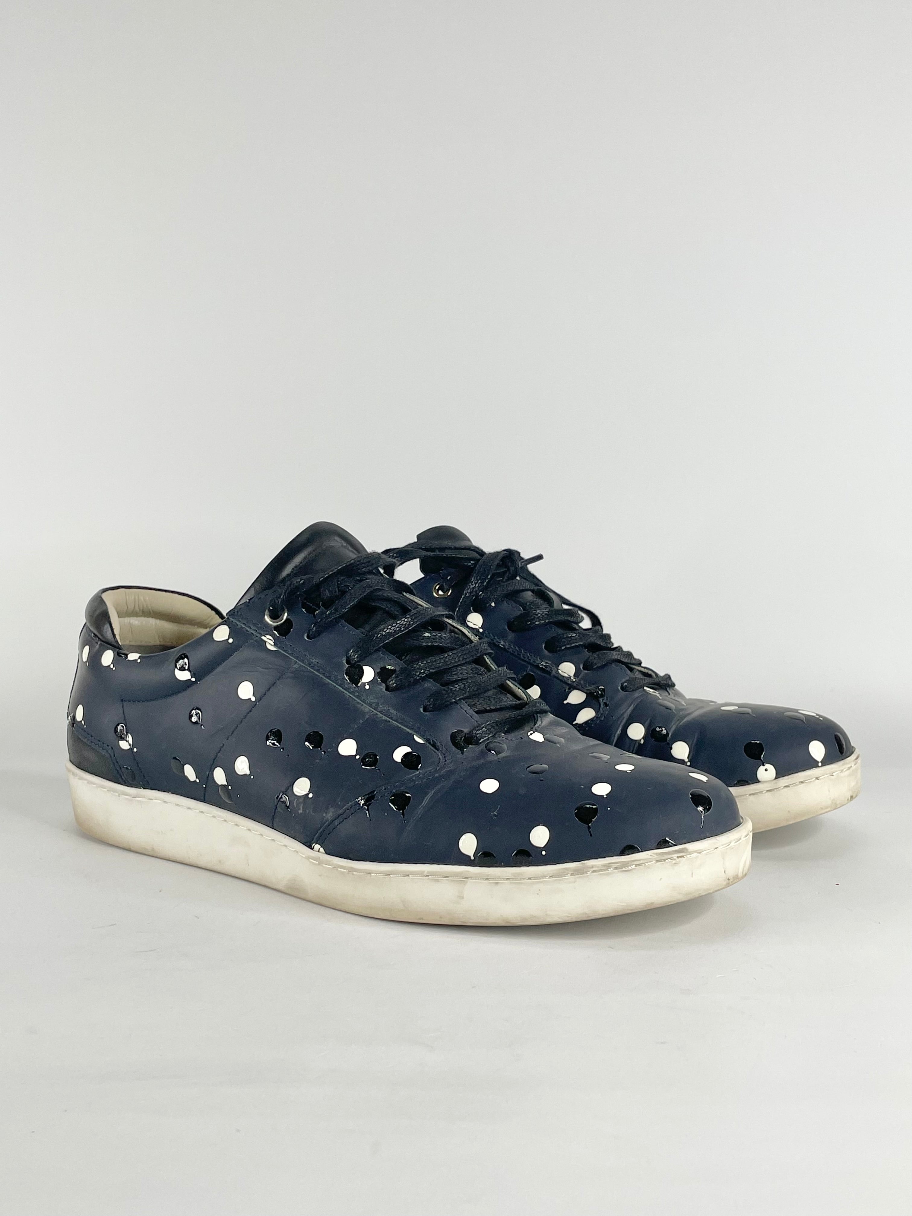 Navy blue leather sneakers with textured black and white dots, with lace-up closure and a flat sole.