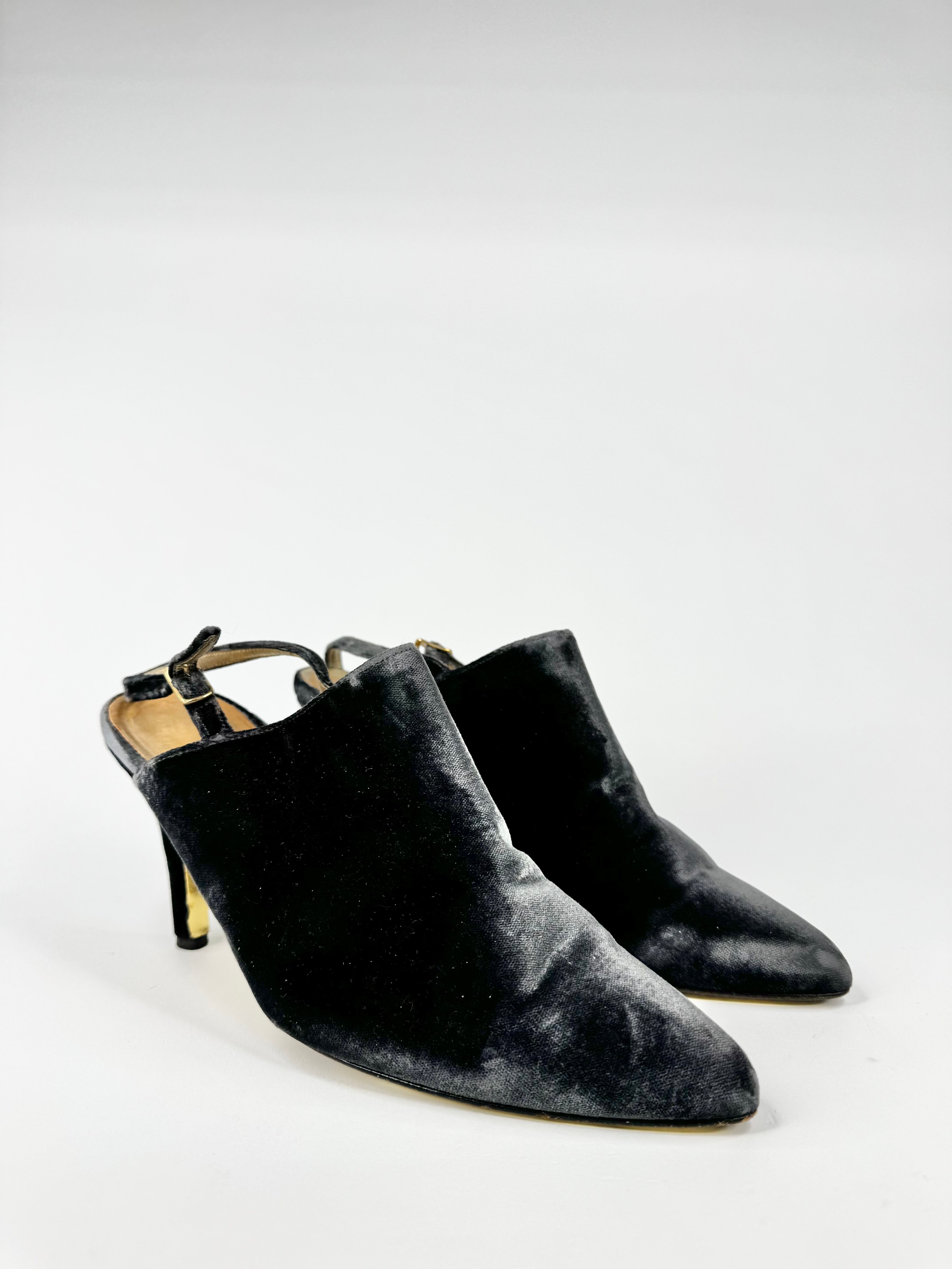 Pair of black velvet high-heeled shoes on a white background