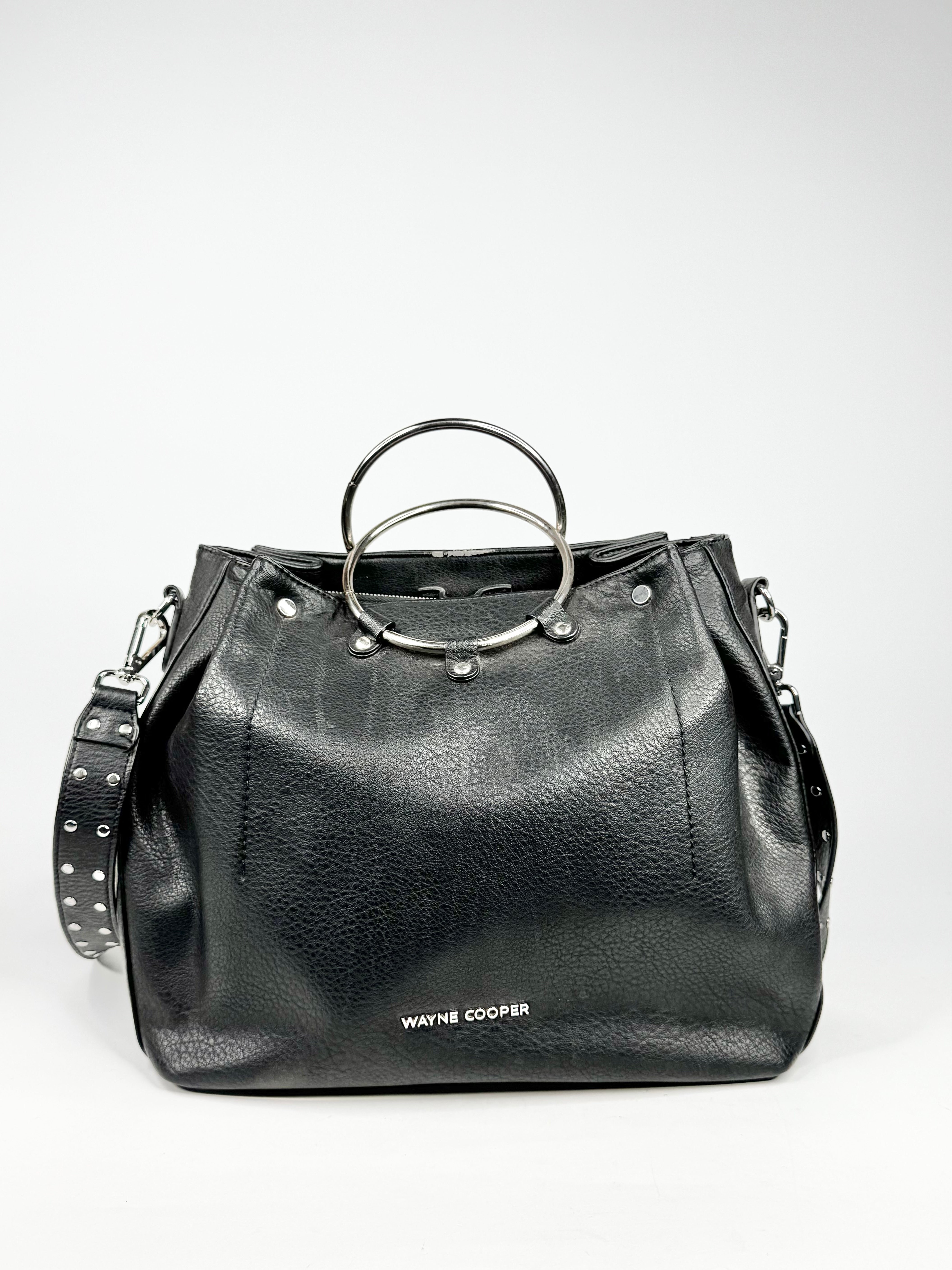 Black leather handbag with circular handle on a white background