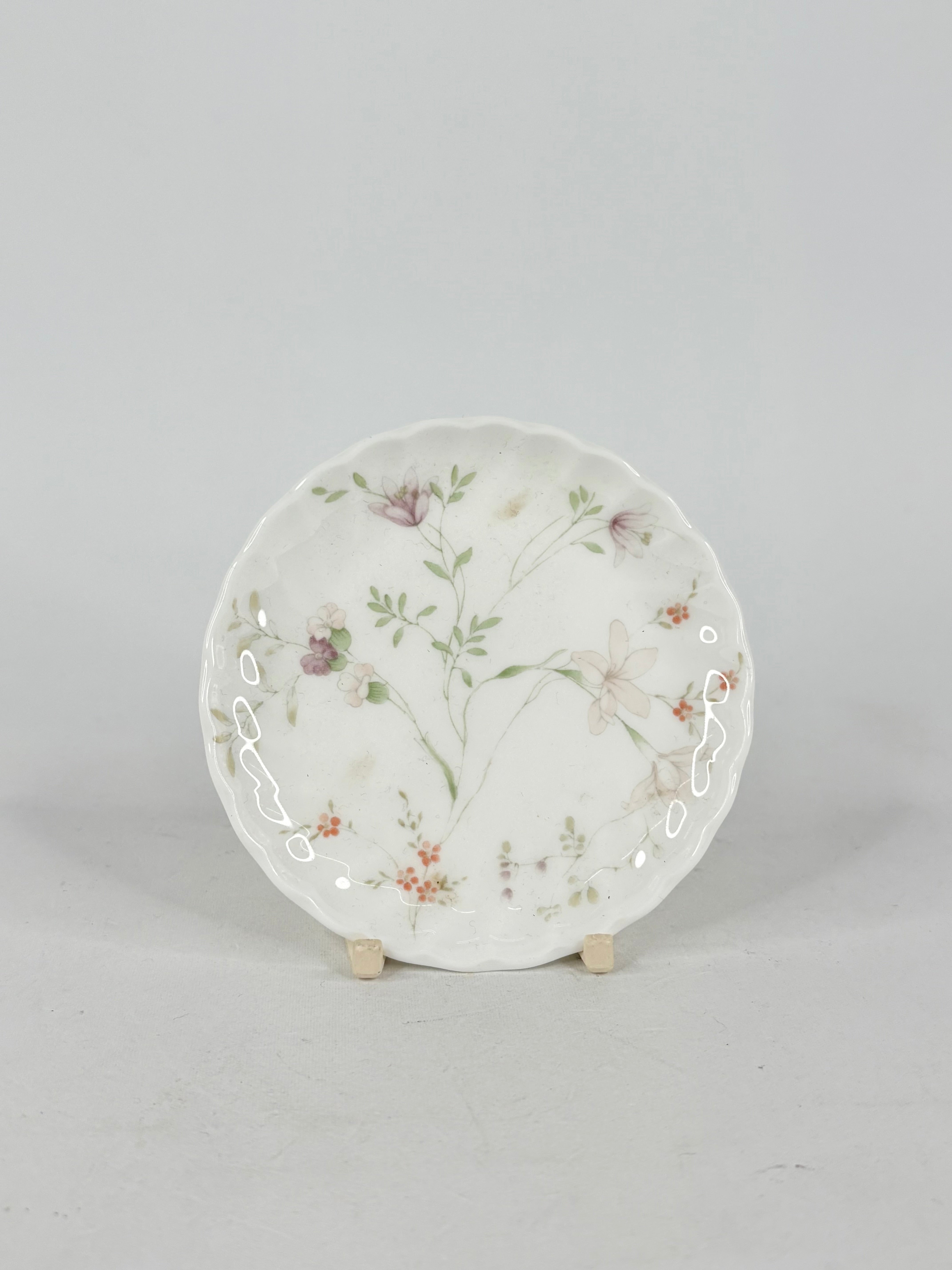 Decorative ceramic plate with floral design on a gray background