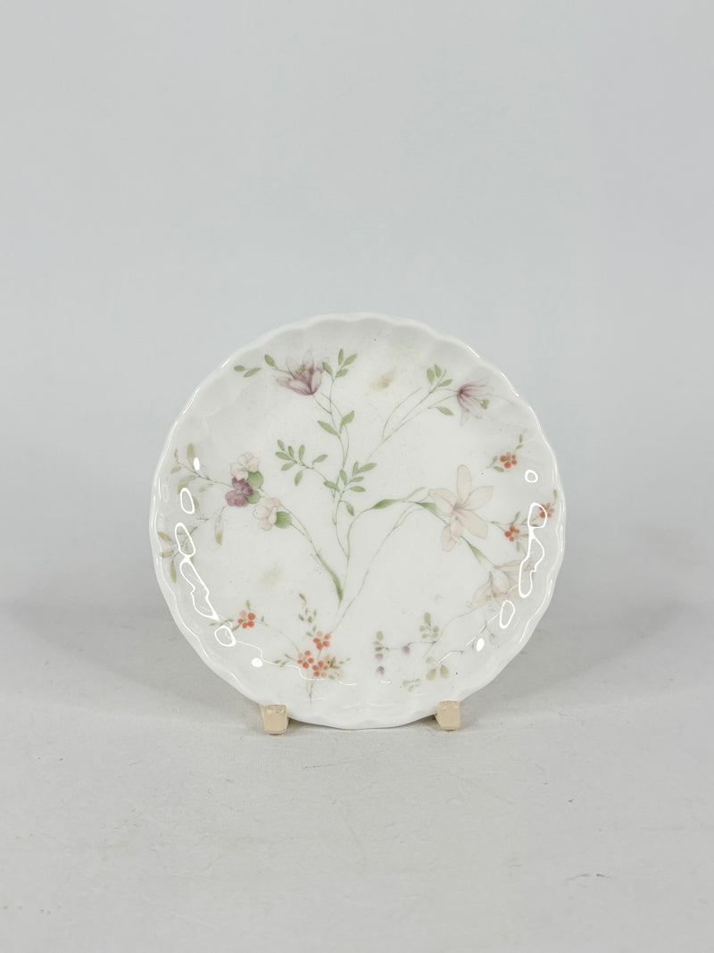 Decorative ceramic plate with floral design on a gray background