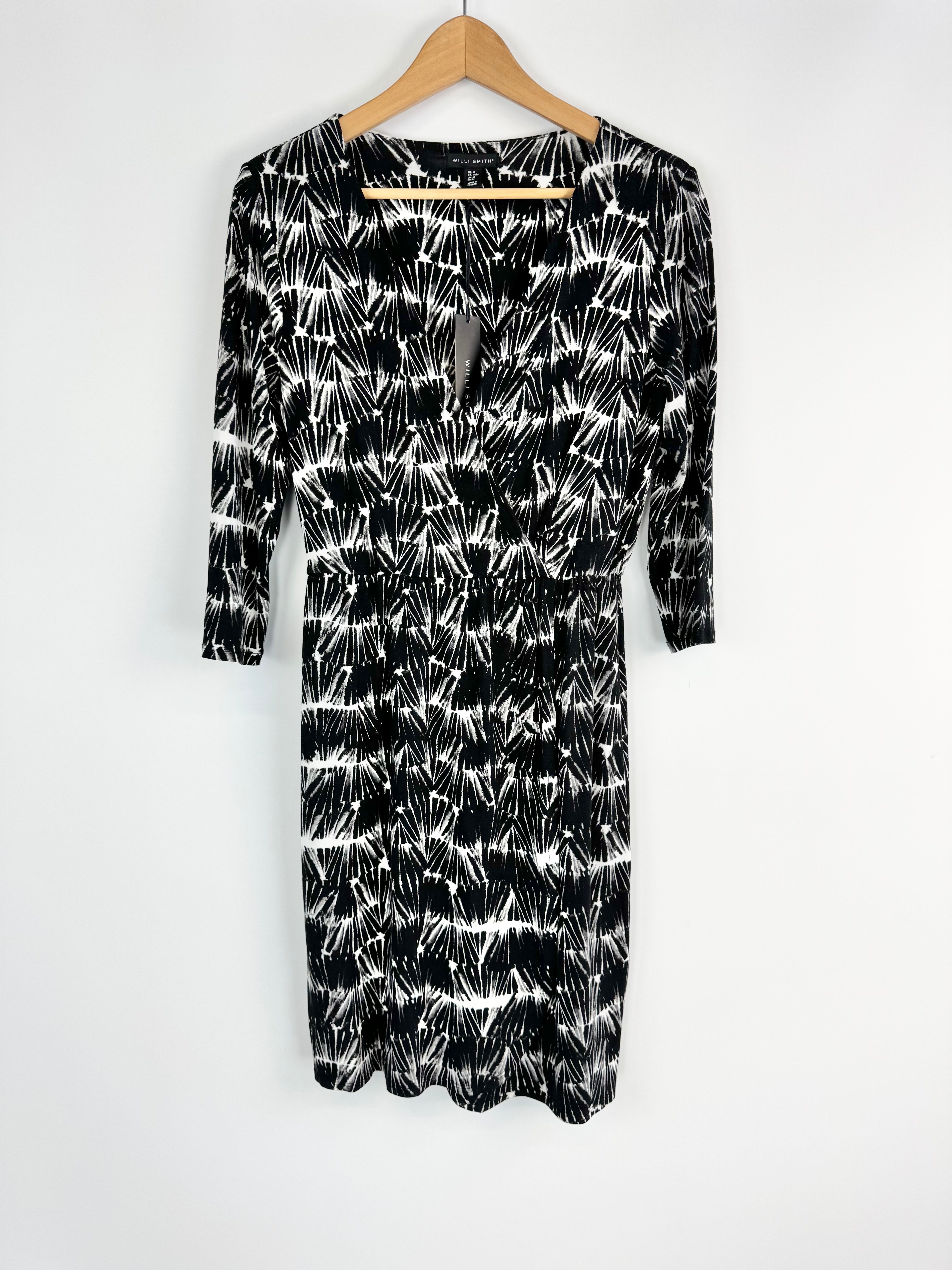 Black and white patterned dress on a hanger against a white background