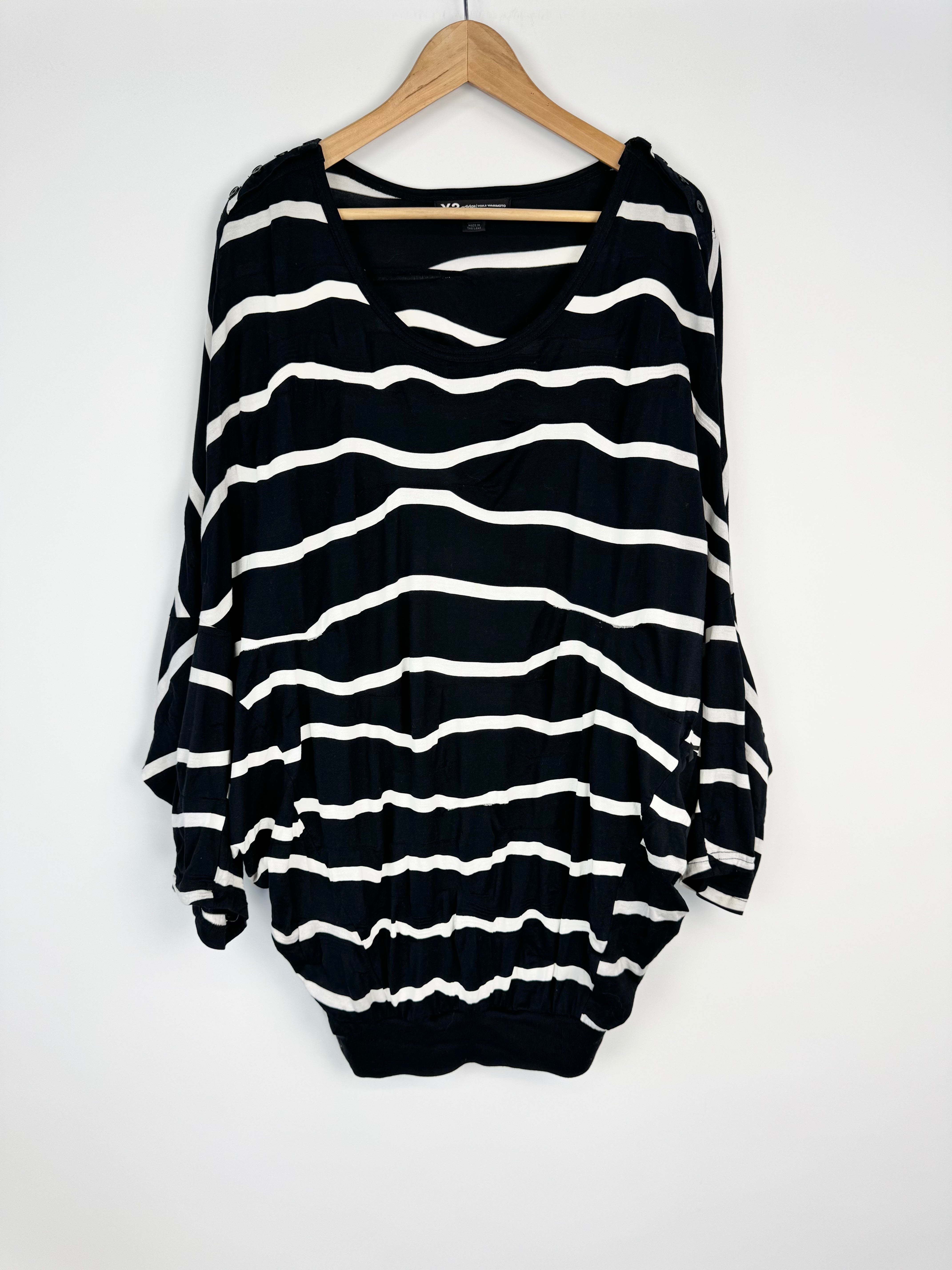 Black and white striped dress on a hanger against a white background
