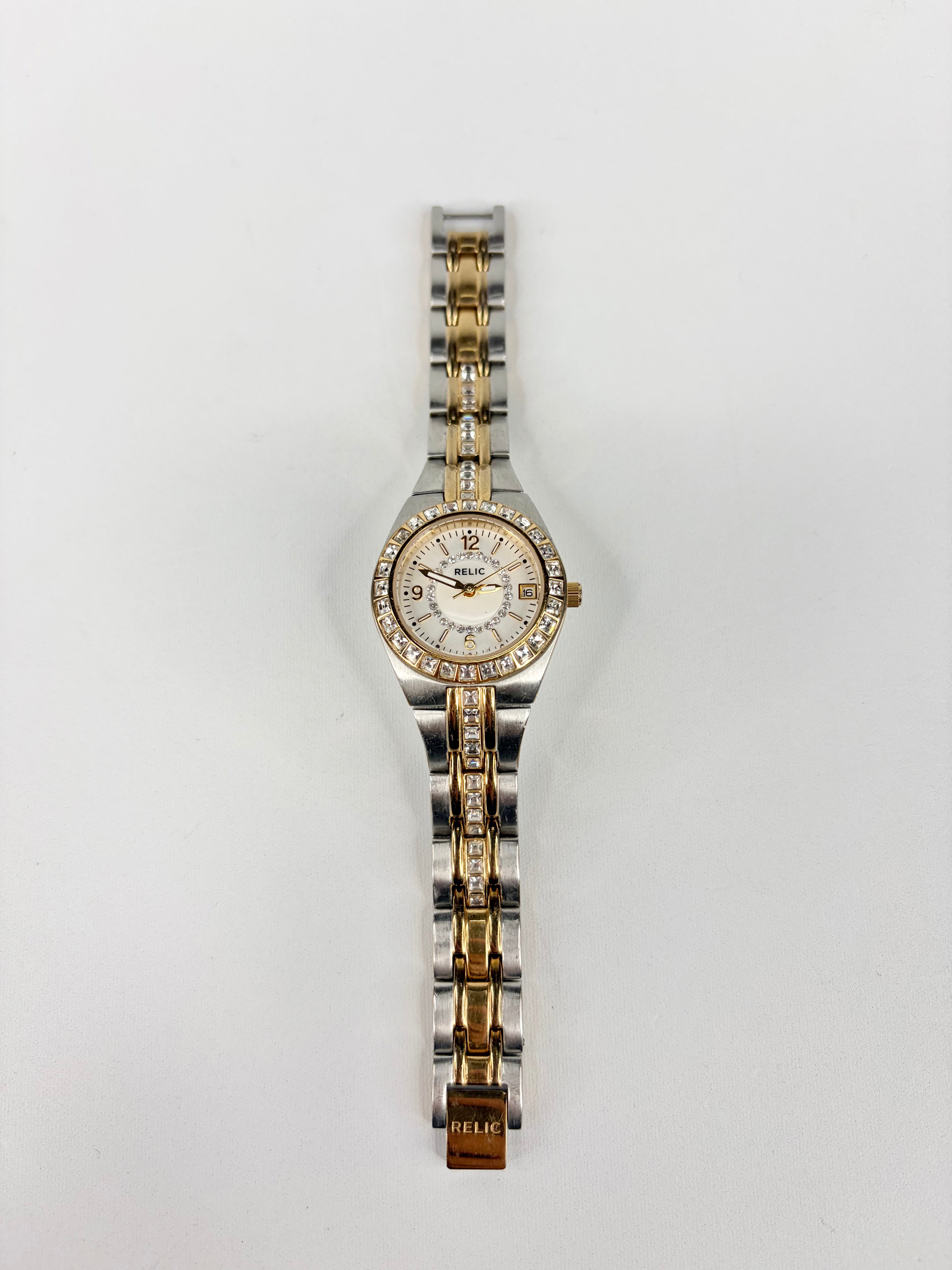 Two-tone watch with diamond-studded bezel on a light gray background