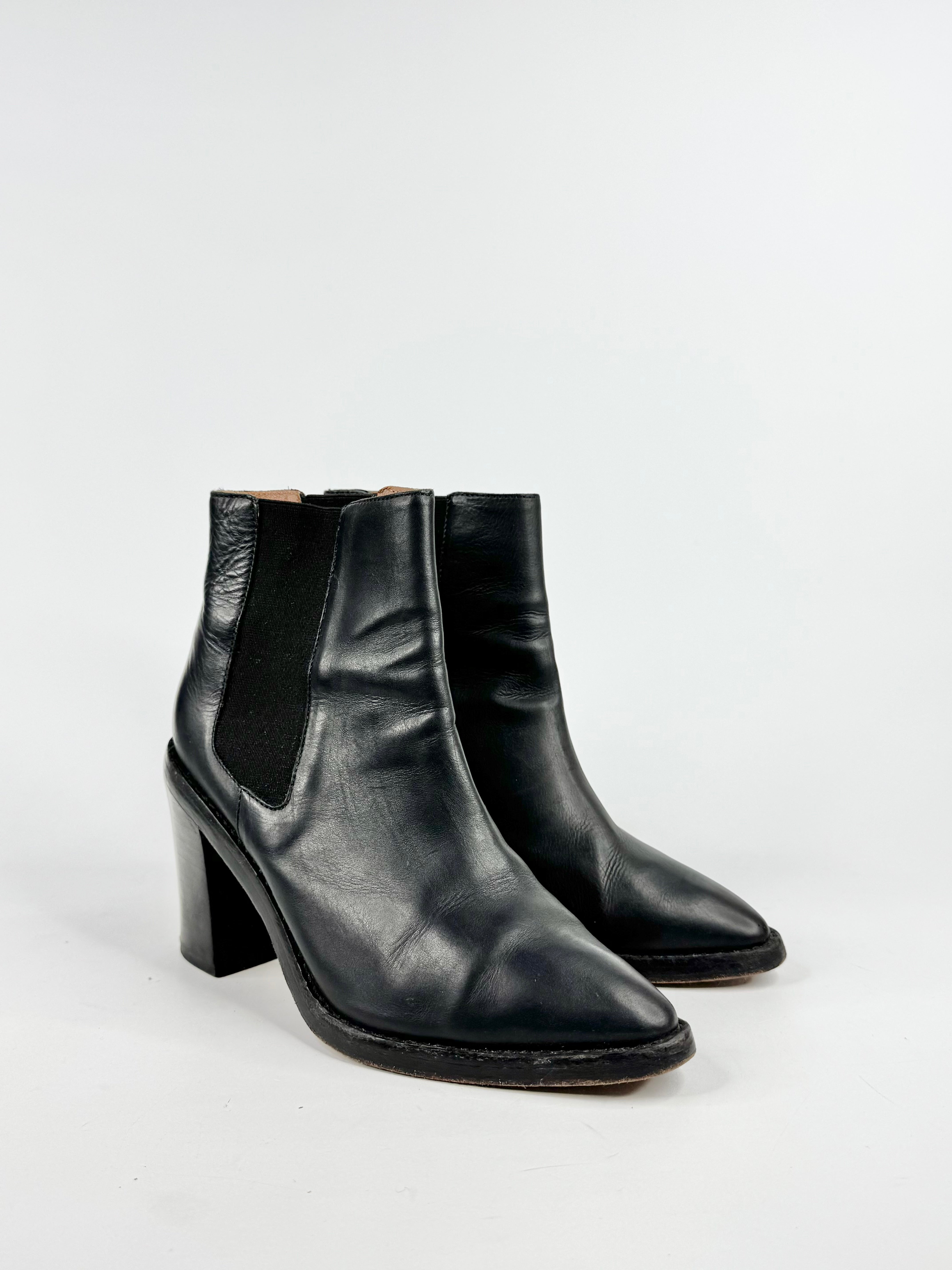 Black leather ankle boots on a white background