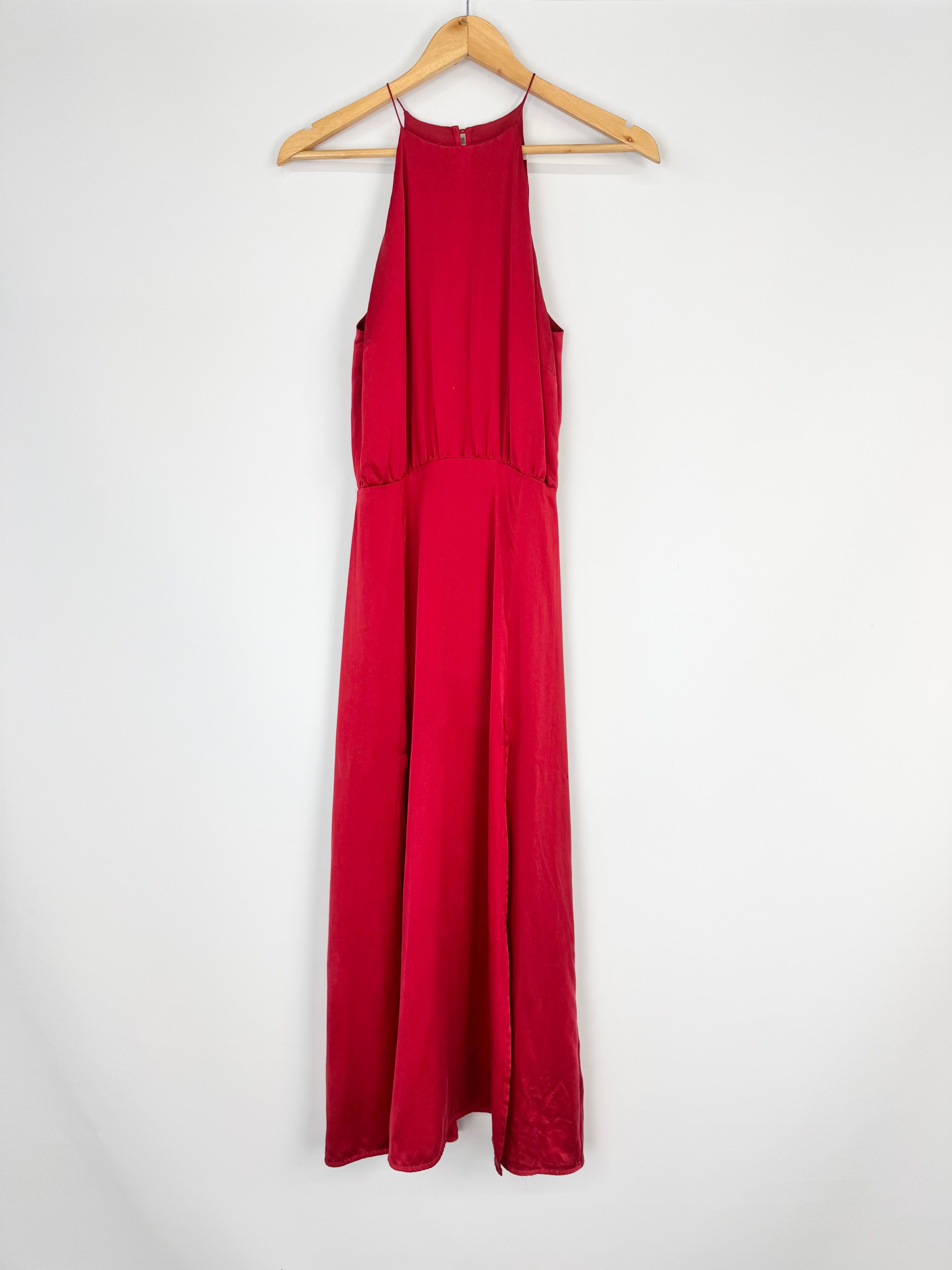 Red jumpsuit on a wooden hanger against a white background