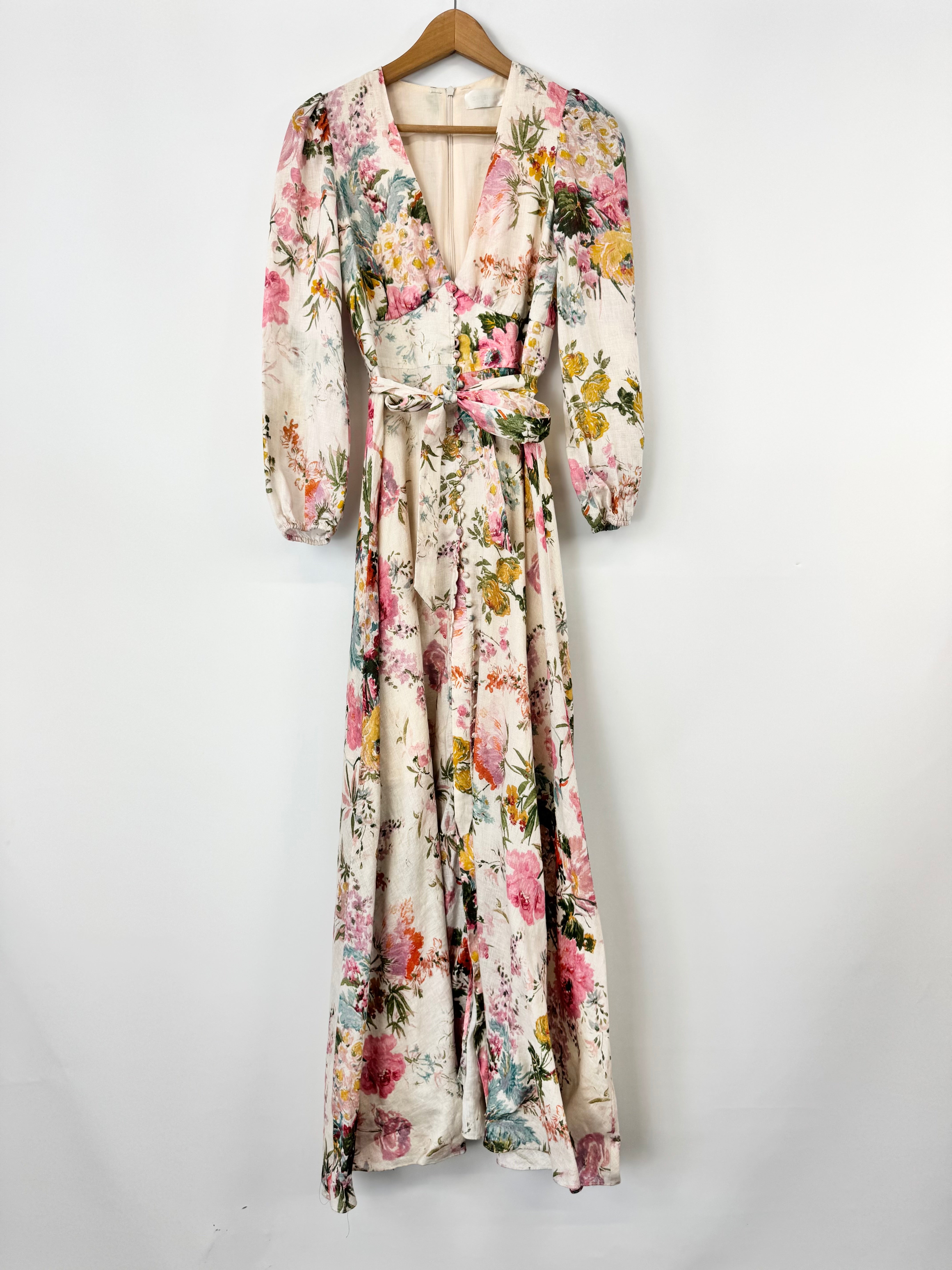 Floral patterned dress on a hanger against a white background