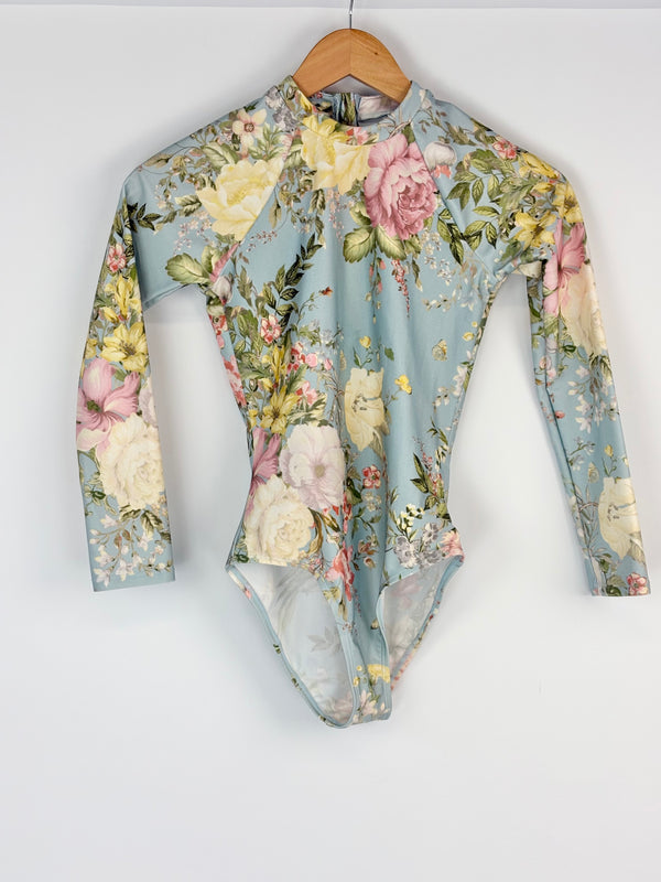 Floral patterned swimsuit on a hanger against a white background